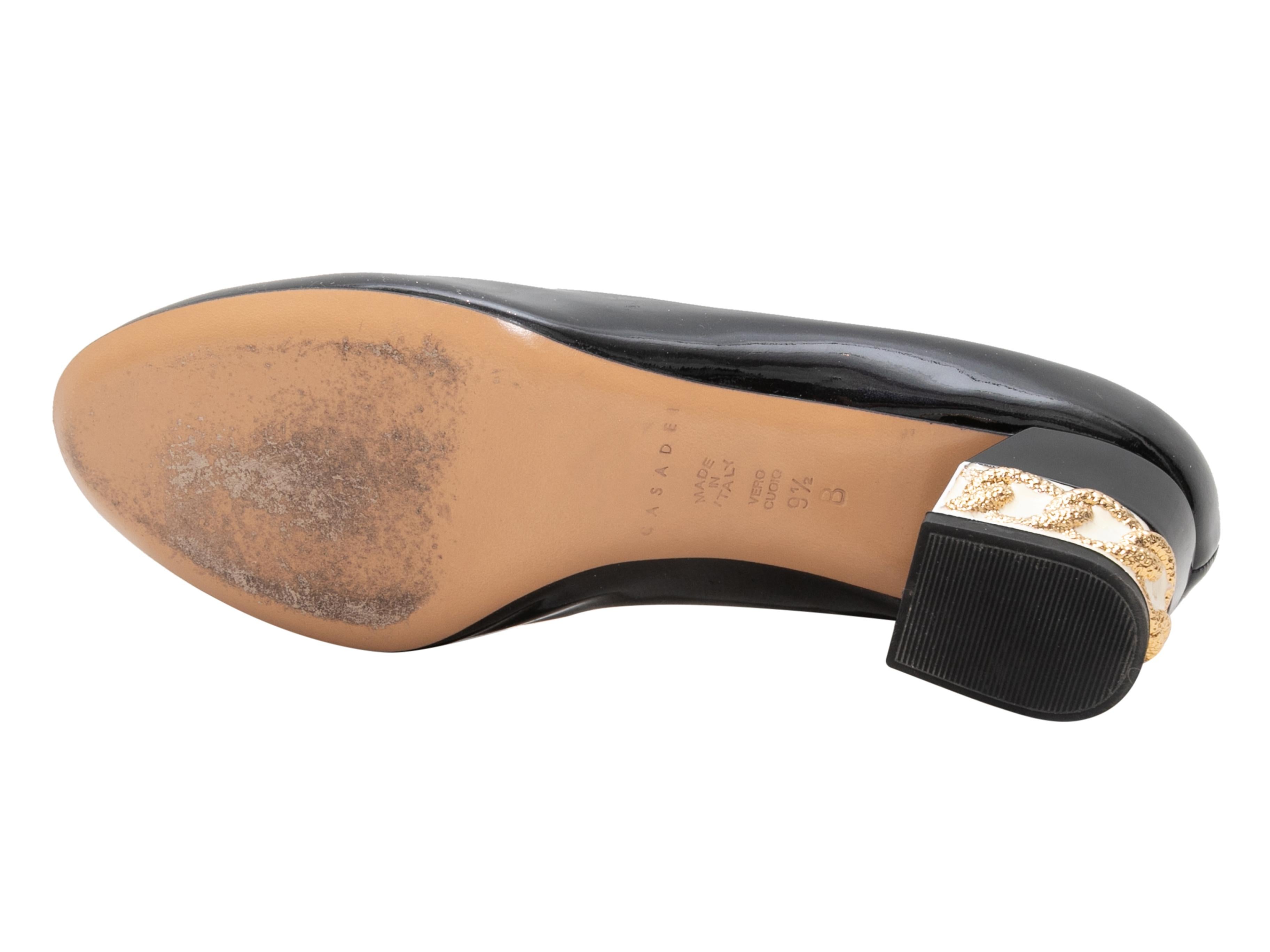 Schwarze, weiße und goldene Pumps aus Lackleder von Casadei. Kettengliedmuster an den Blockabsätzen. 2,25