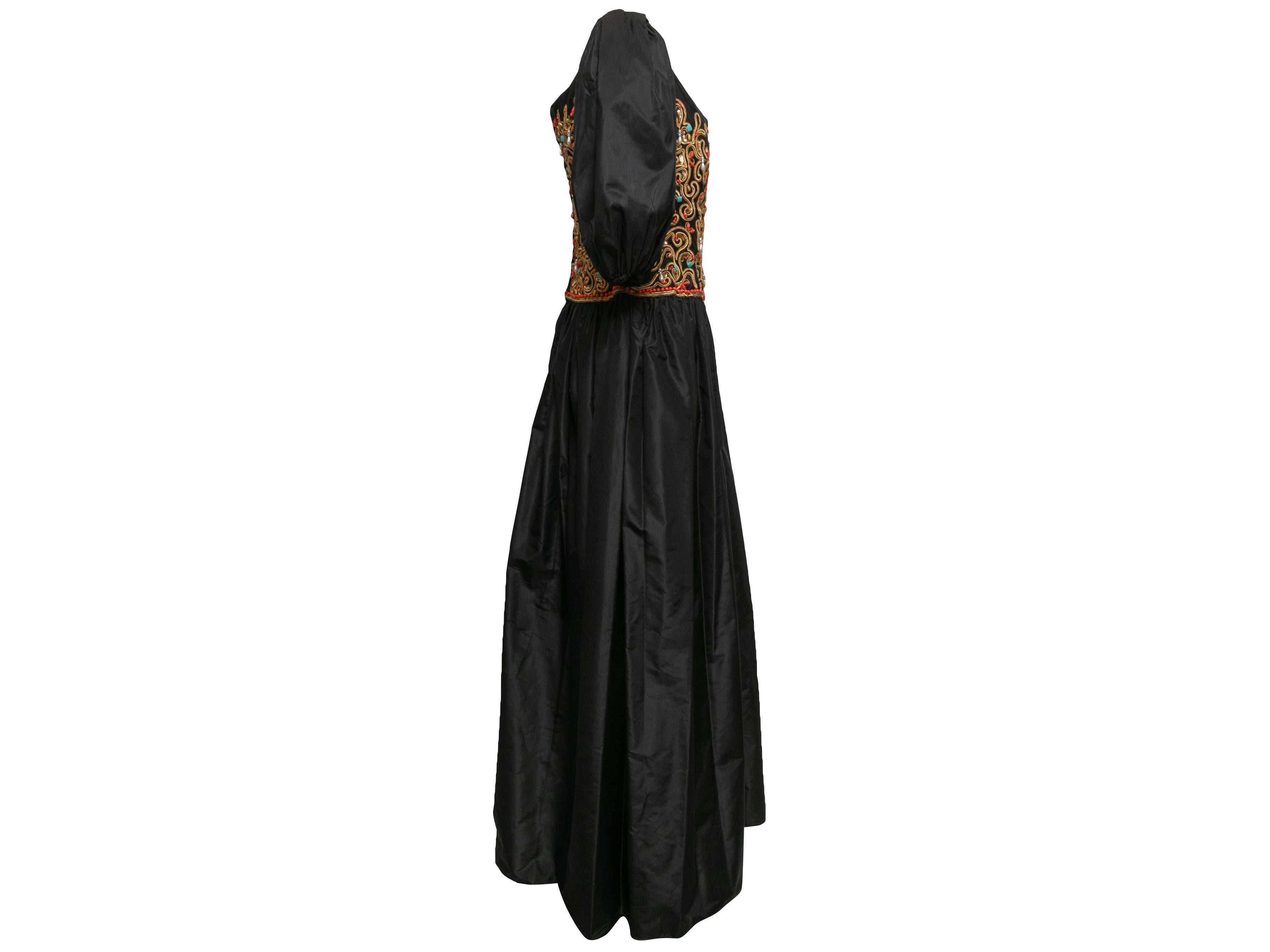 Schwarzes Puffärmel-Kleid von Richilene. Rundhalsausschnitt. Mehrfarbige Perlenverzierungen im gesamten Mieder. Reißverschluss in der hinteren Mitte. 33