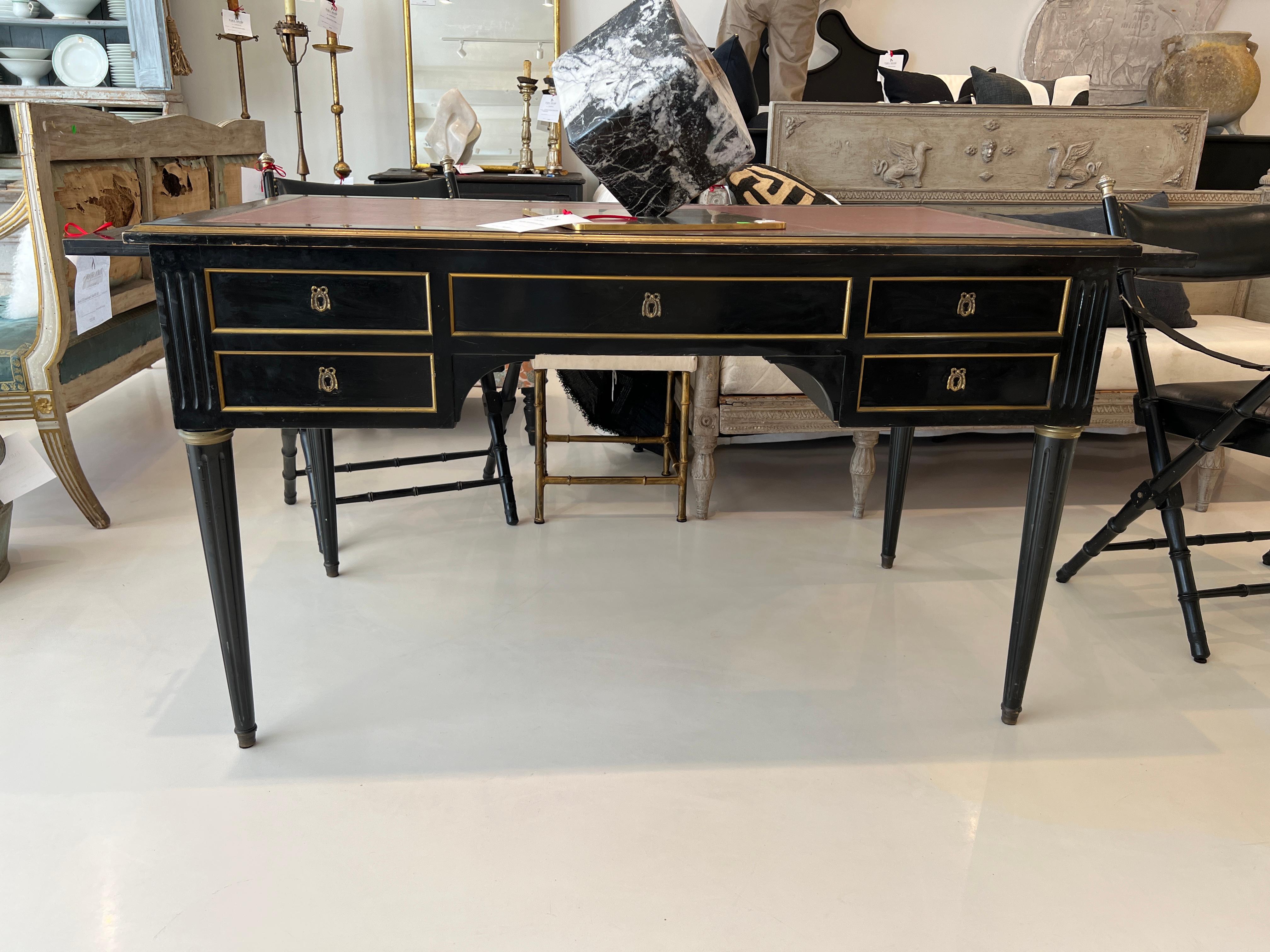 Straight lines define this elegant desk in black and gold with a red leather top. Added enhancements are the pull-out leather topped platforms on either side.