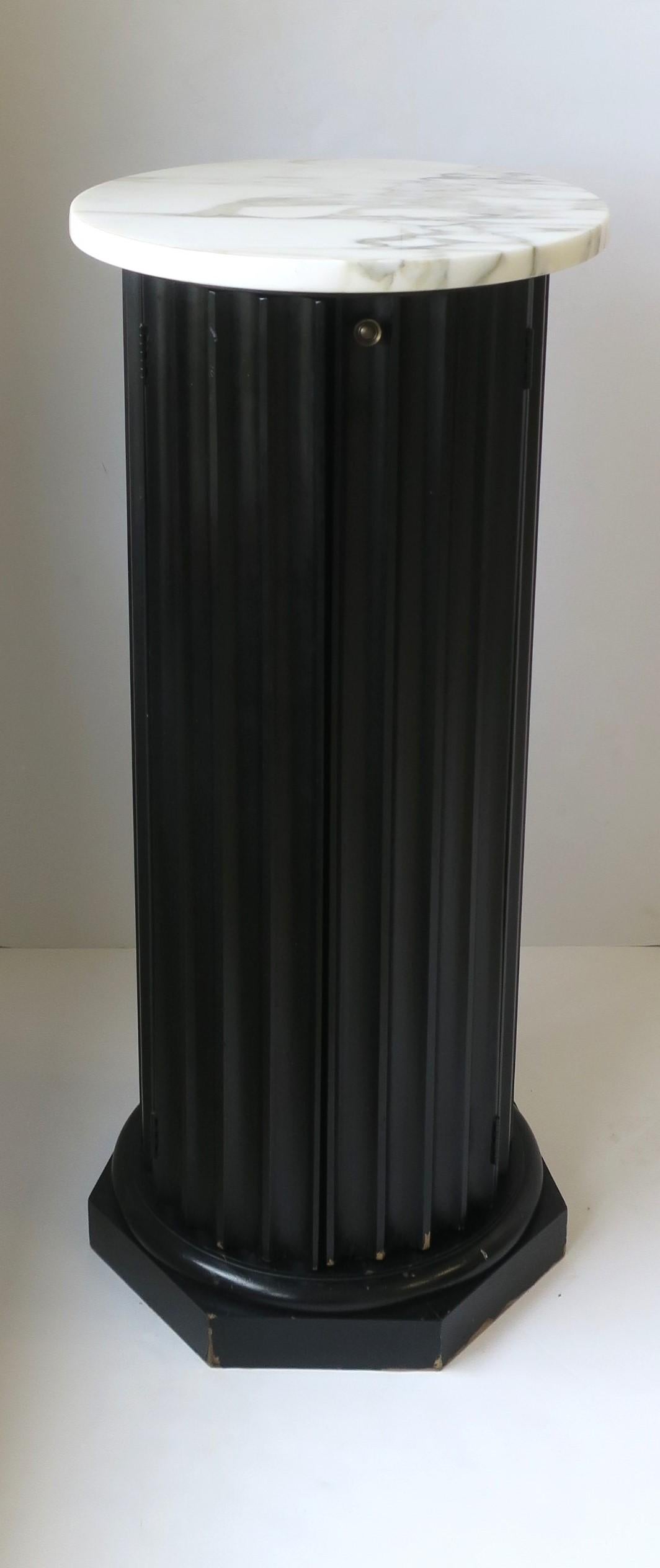 **There are two pedestals available, each sold separately, as per listing. 

A beautiful black fluted wood and white marble top pillar column pedestal stand in the Neoclassical design style, circa mid to late-20th century. Fluted wood pedestal is