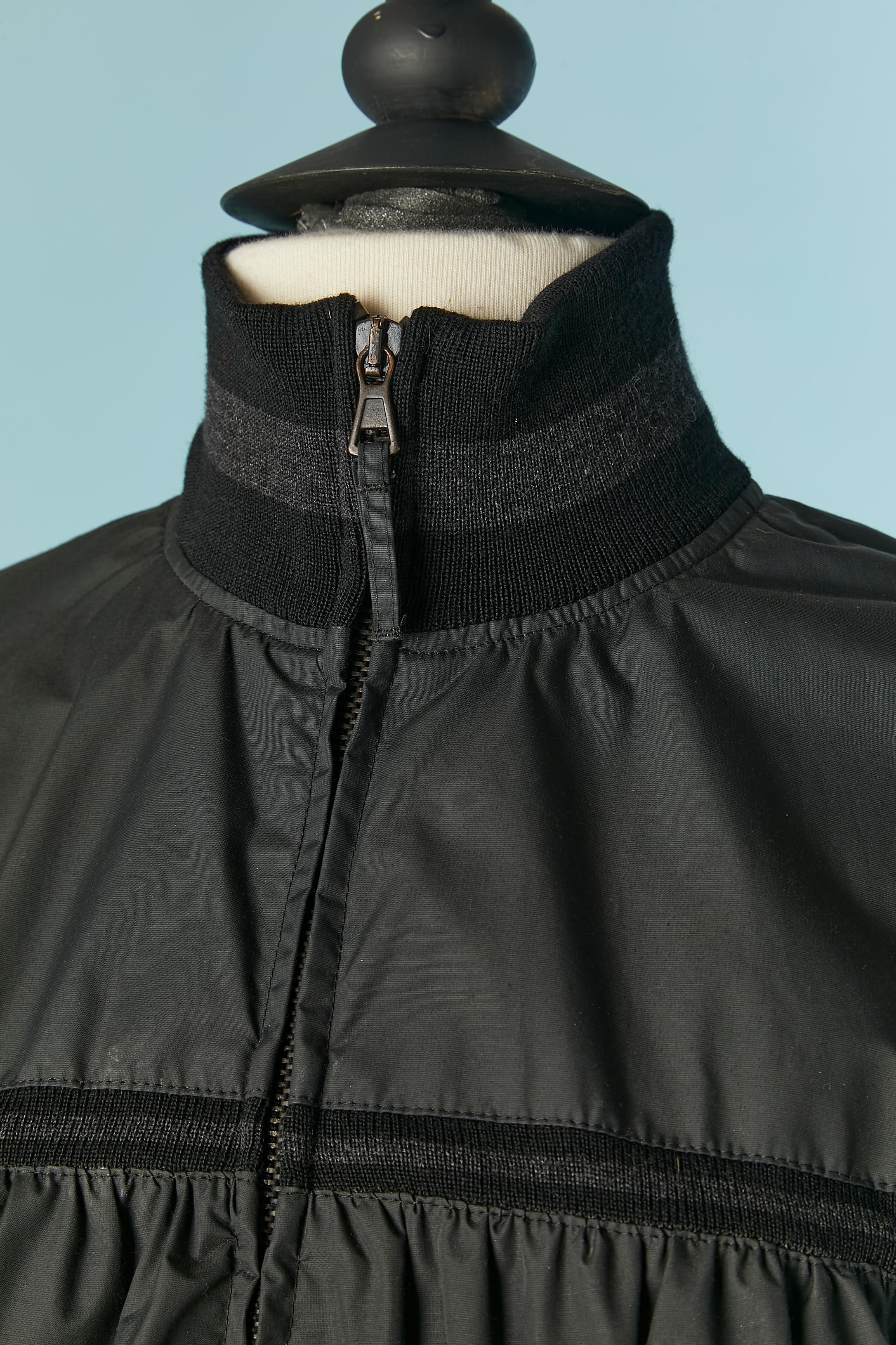 Black nylon jacket with knit-ribbed collar and bottom. Main fabric: 50% nylon, 26% cotton, 19% polyurethane.
Lining: 70% acetate, 30% silk. 
Zip closure in the middle front. Pocket on both side. 
SIZE 