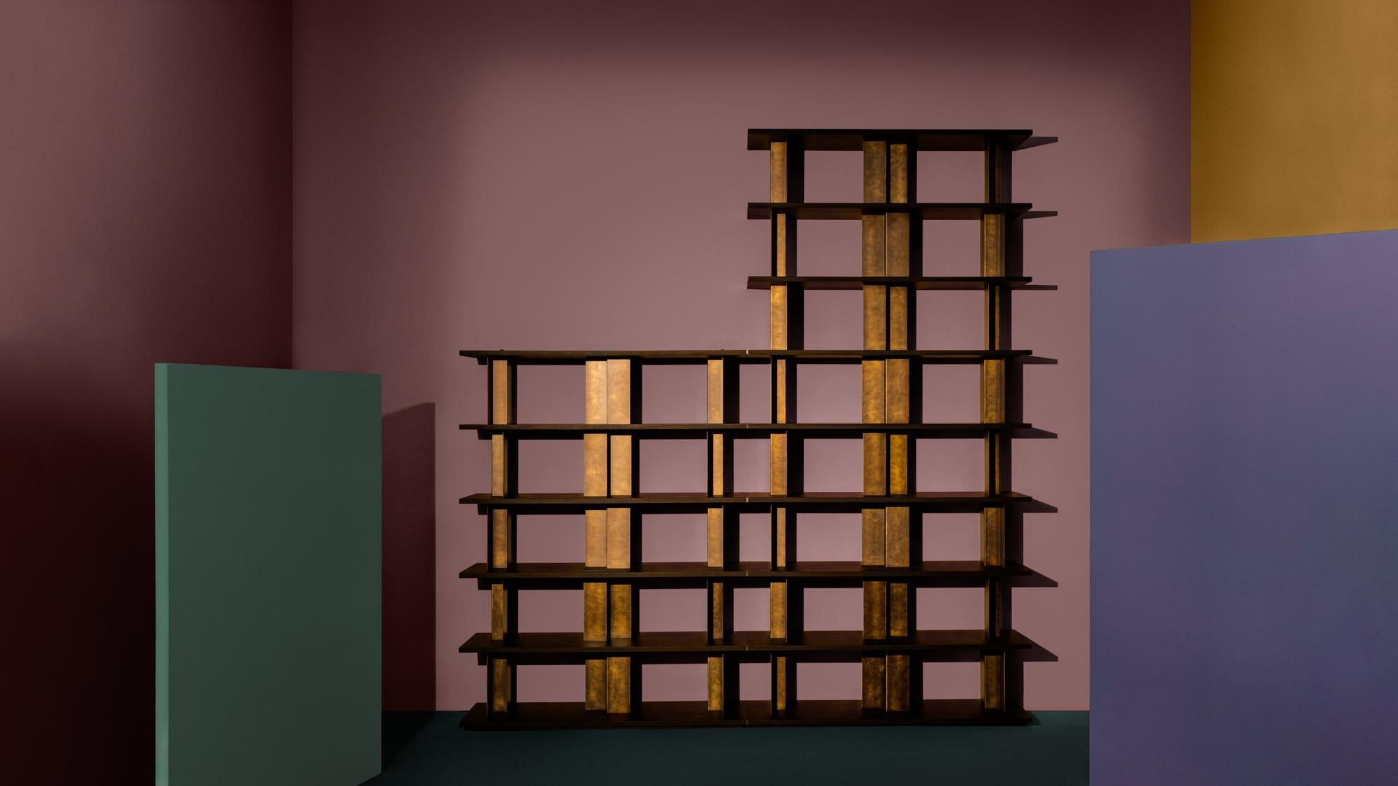 Reana, a modular bookcase, is the result of a rigorous approach to design by Oliver Thomas Wall. Like architecture, the bookshelf stands out on the wall, powerful and light at the same time. 
The black wood shelves interact with the metal surfaces