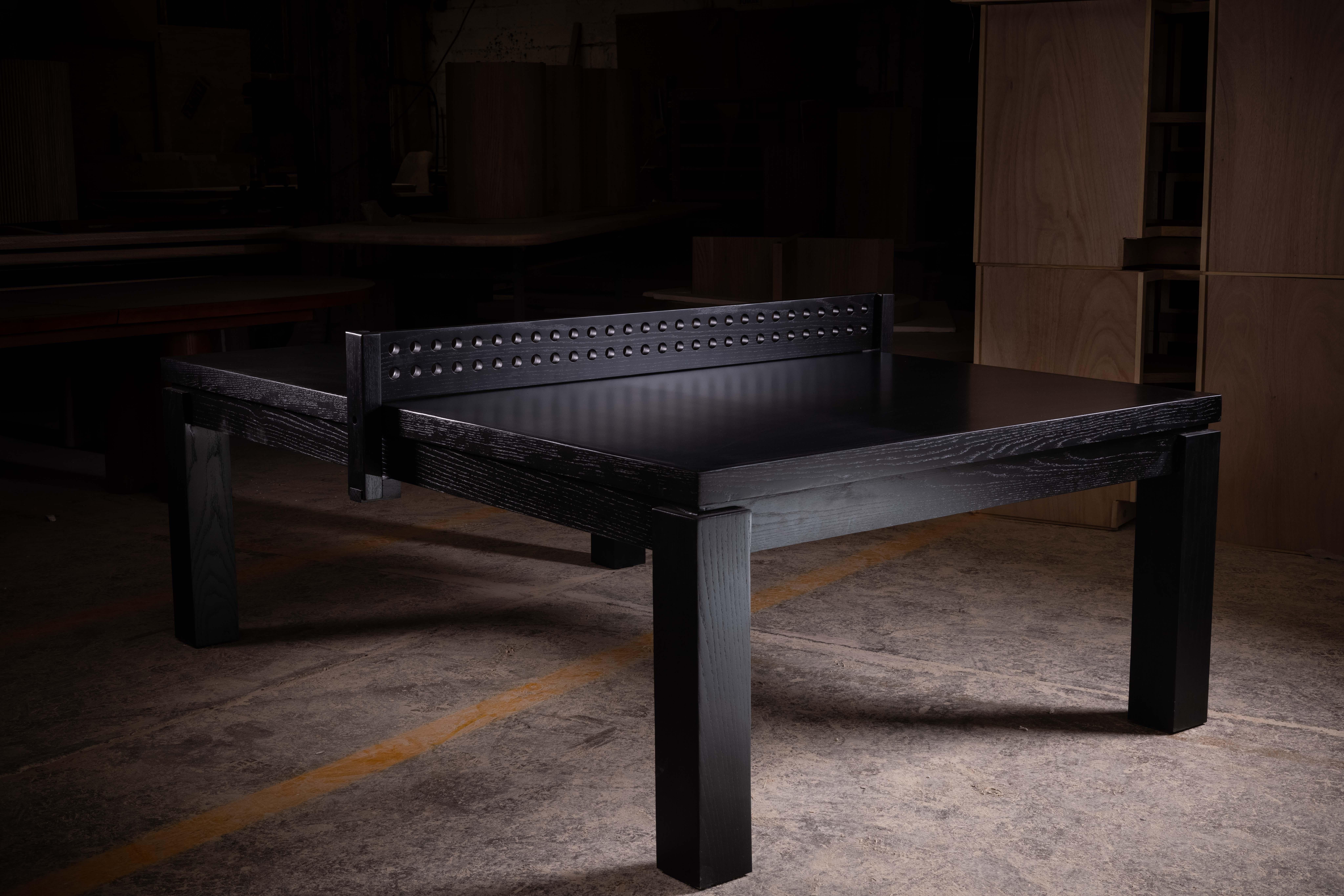 Table de ping-pong en chêne massif avec une finition lisse teintée en noir. Le filet est fabriqué en chêne massif.
