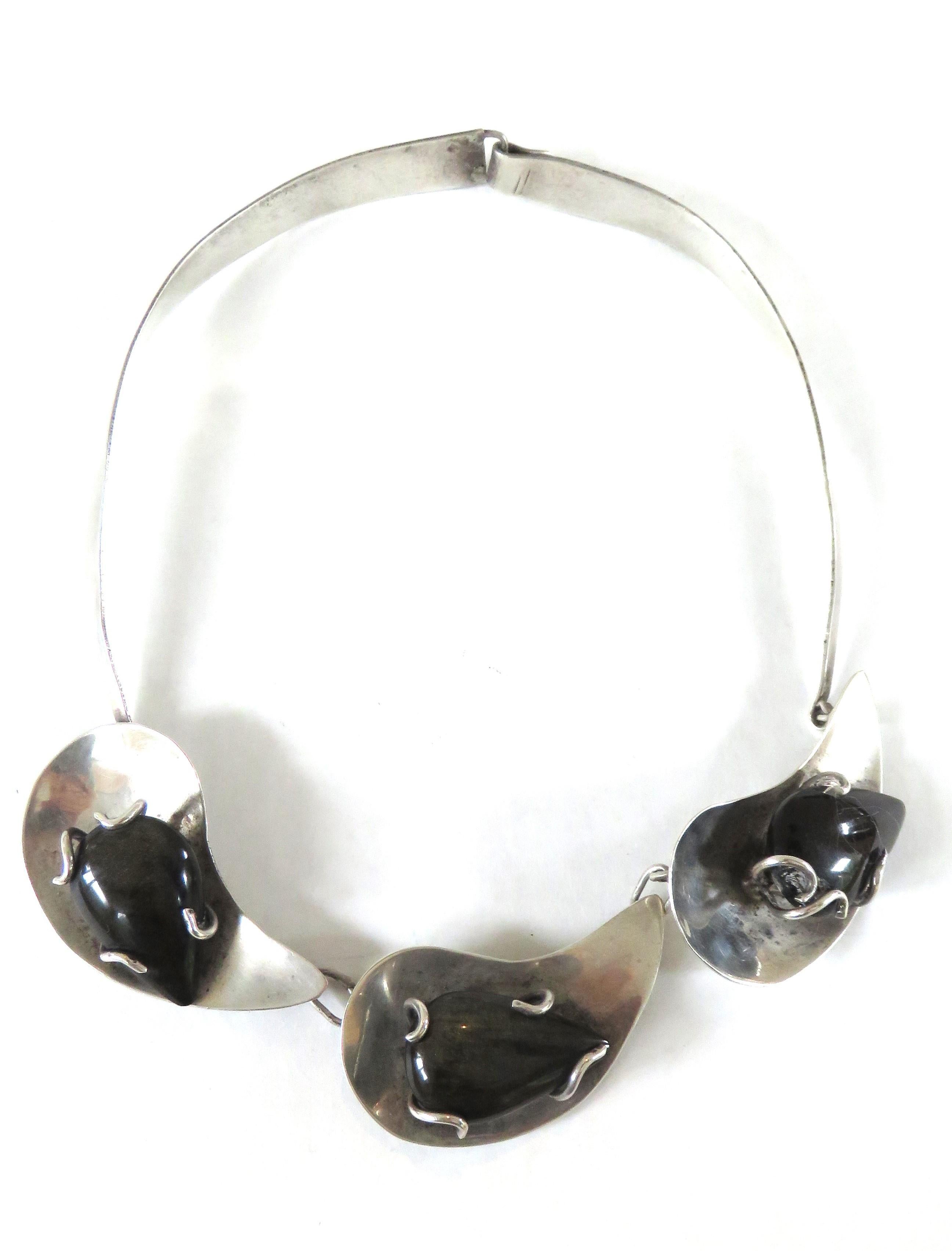 Una splendida collana di ossidiana nera e argento sterling composta da tre gocce di ossidiana in sterling unite da grandi maglie d'argento su un nastro di sterling. Ha una chiusura a gancio.

Lunghezza interna  16