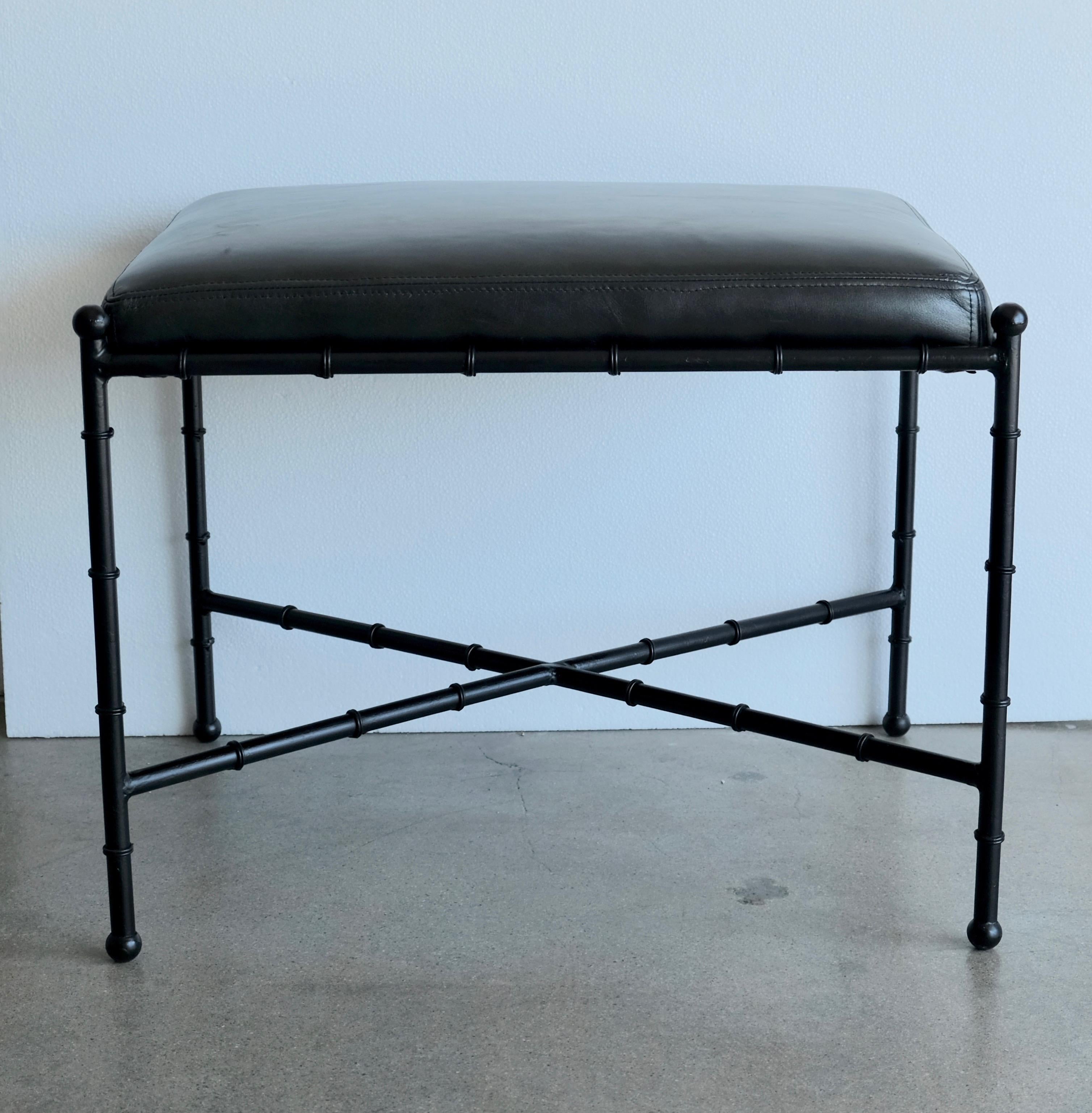 A restored vintage vanity stool or small bench. The metal base is fashioned in a bamboo style. The freshly upholstered fixed cushion is done in Italian black leather.