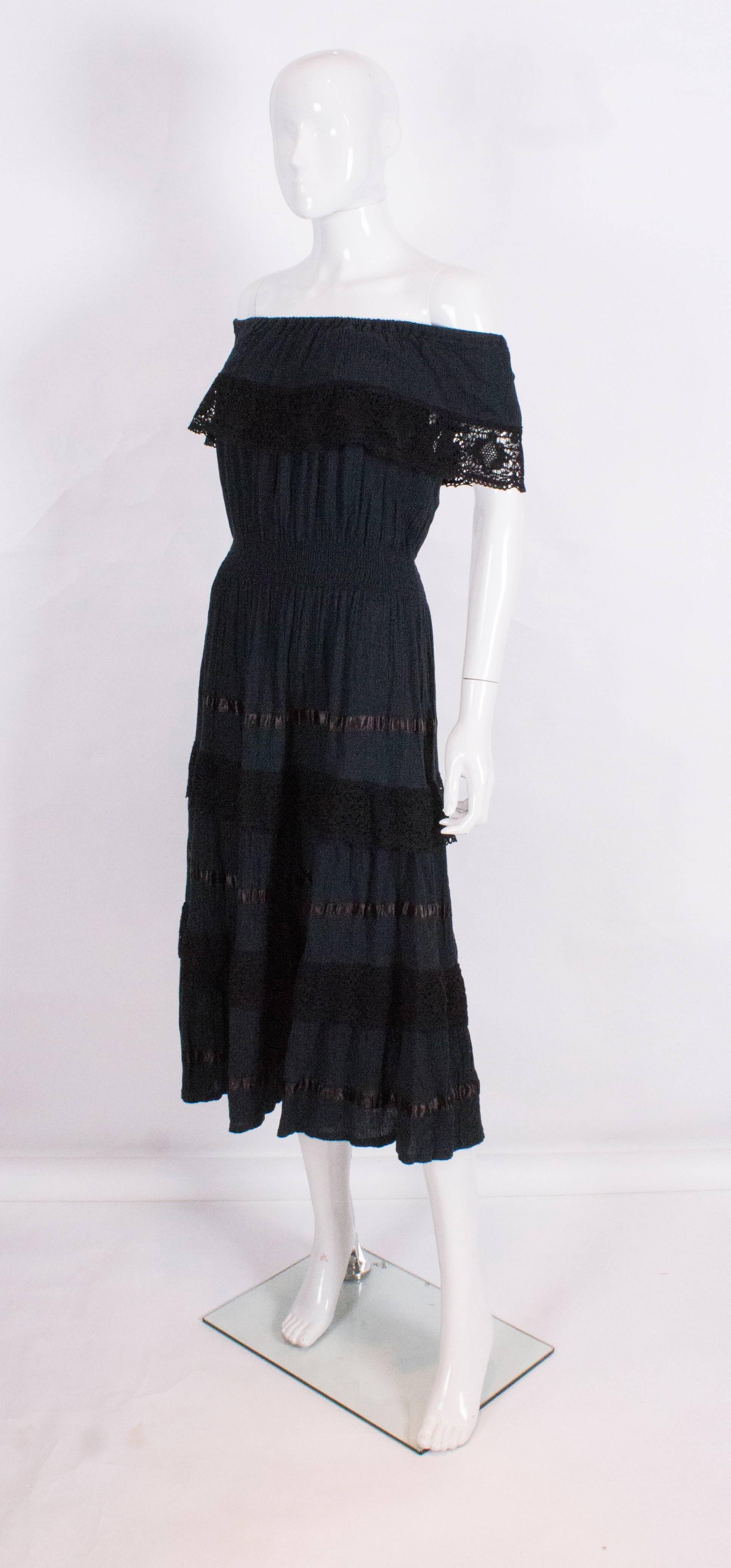 A chic cotton black on/off shoulder dress with an elasticated waist, flared skirt with ribbon and crochet detail. Perfect for summer. The waist measure 22'', but as it is elasticated, can stretch.