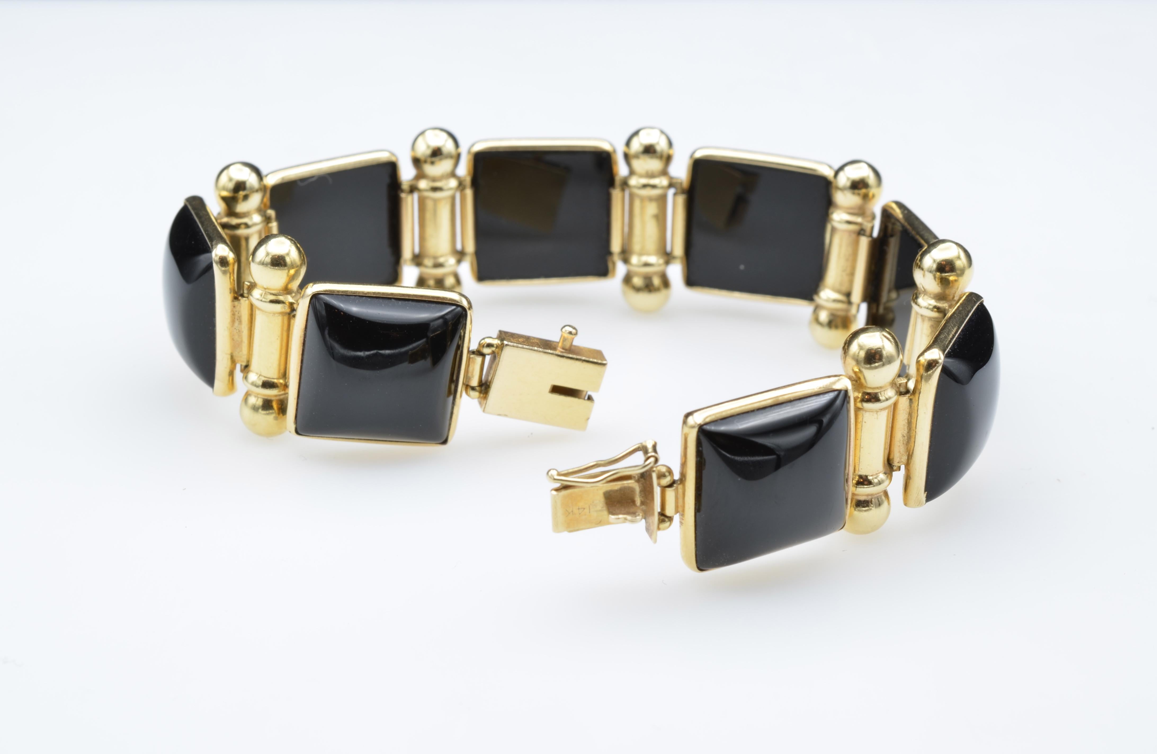 This link bracelet is modern and sleek. Squares of black onyx are framed in 14k with scroll hinges. Reminiscent of Grace Kelly in 