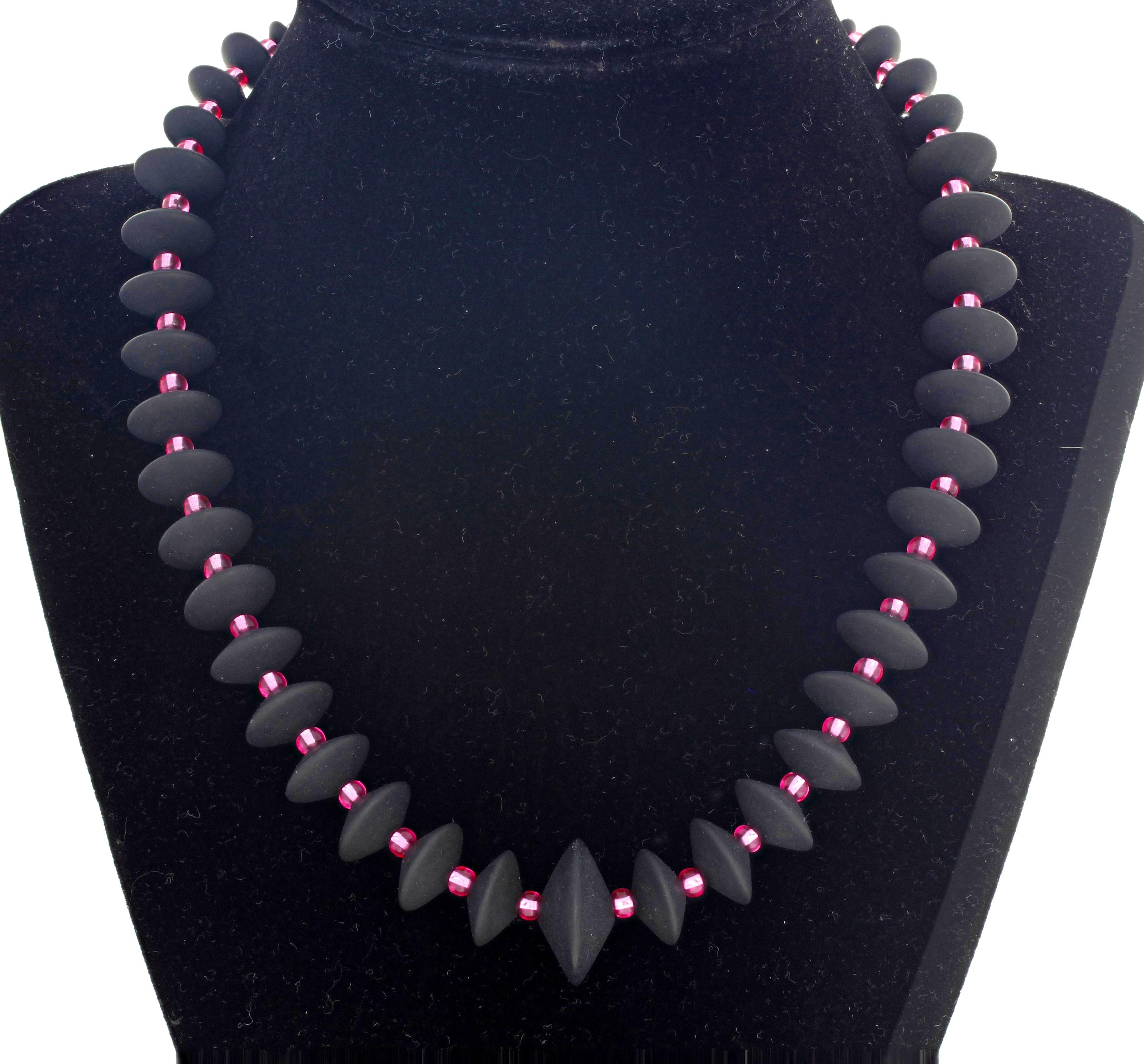 Black Onyx rondels (largest is 20 mm) enhanced with glittering brilliant pinky Czech crystals set in a unique handmade 17.5 inch long necklace with goldy hook clasp.  This stands out magnificently on a blouse or sweater.