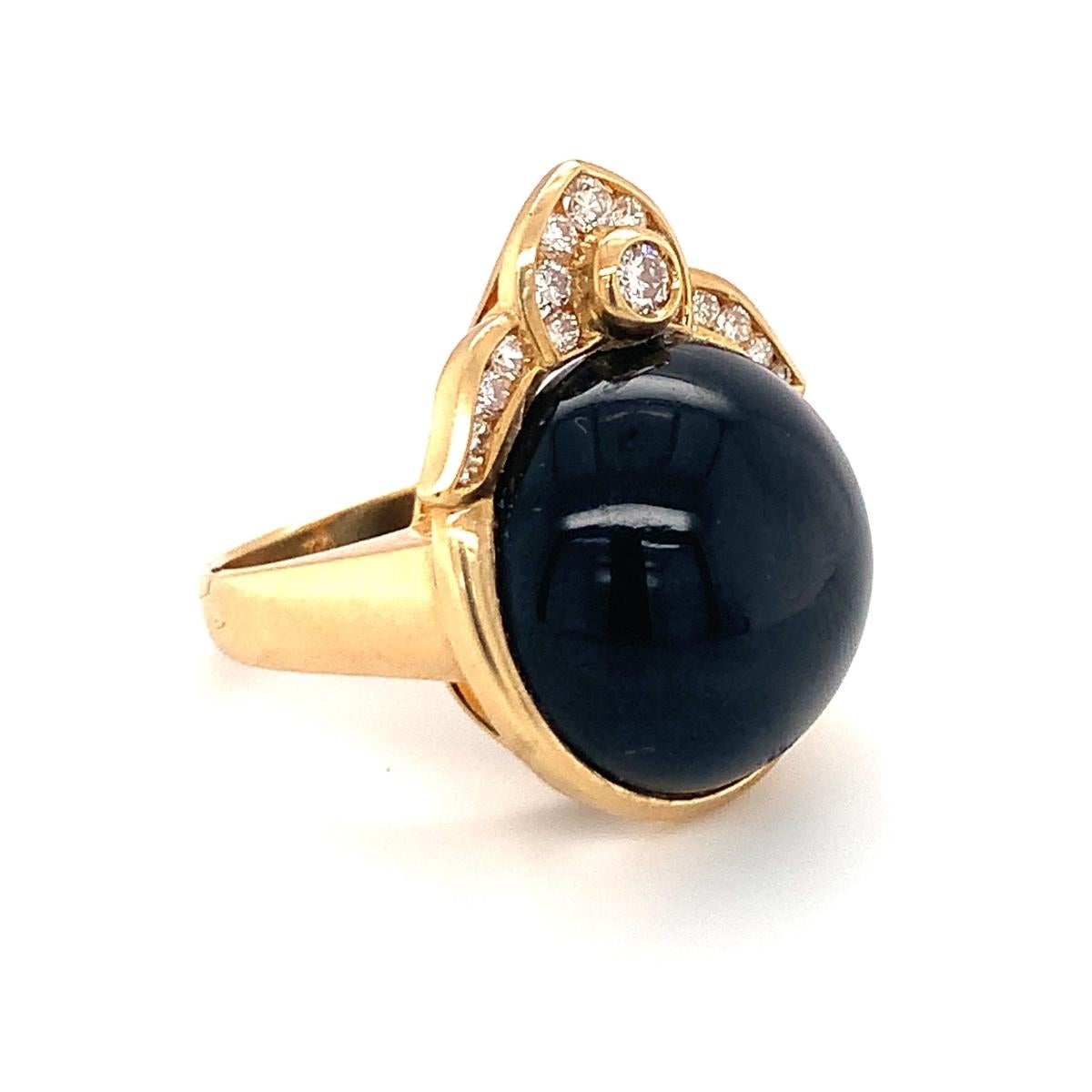 One black onyx and diamond 18K yellow gold ring centering one round cabochon black onyx stone measuring 8 millimeters in diameter with 15 round brilliant cut diamonds weighing approximately 0.75 ct. Crown motif design mount.

Sleek, impressive,