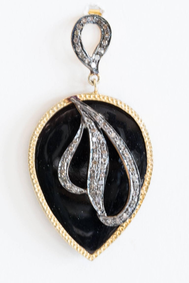 Black onyx teardrop shaped earrings with pave`-set diamonds set in sterling silver overlaid on top.  Bordered in 18K gold vermeil.  Diamonds also on the 18K gold post, for pierced ears.  Onyx is 68.24 carats and diamonds are 1.25 carats.