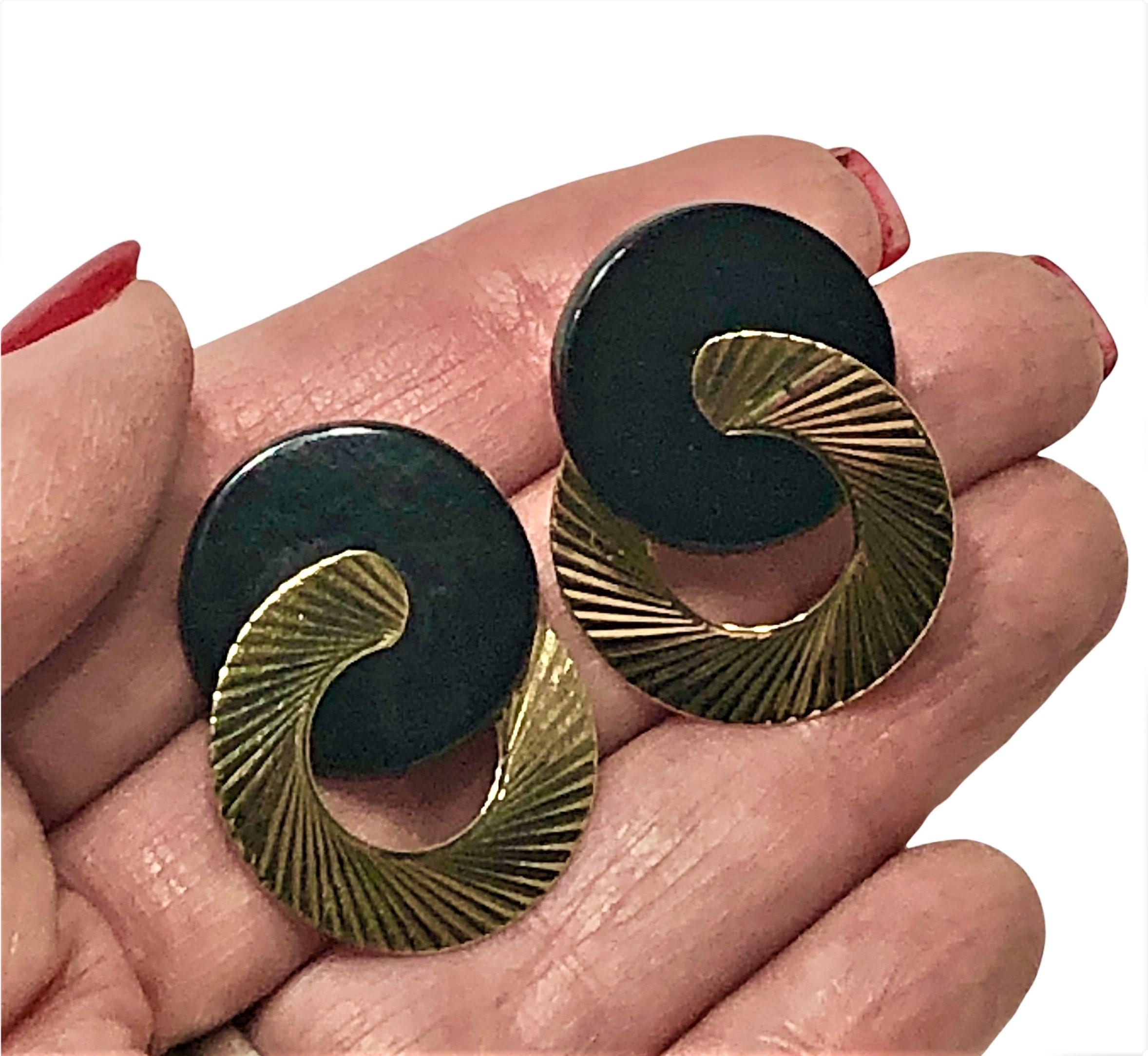 Cette superbe paire de boucles d'oreilles modernistes est composée de disques d'onyx imbriqués et de disques d'or jaune 14K cannelés qui brillent à la lumière. Chaque disque en onyx mesure 3/4 de pouce de diamètre et chaque disque en or cannelé