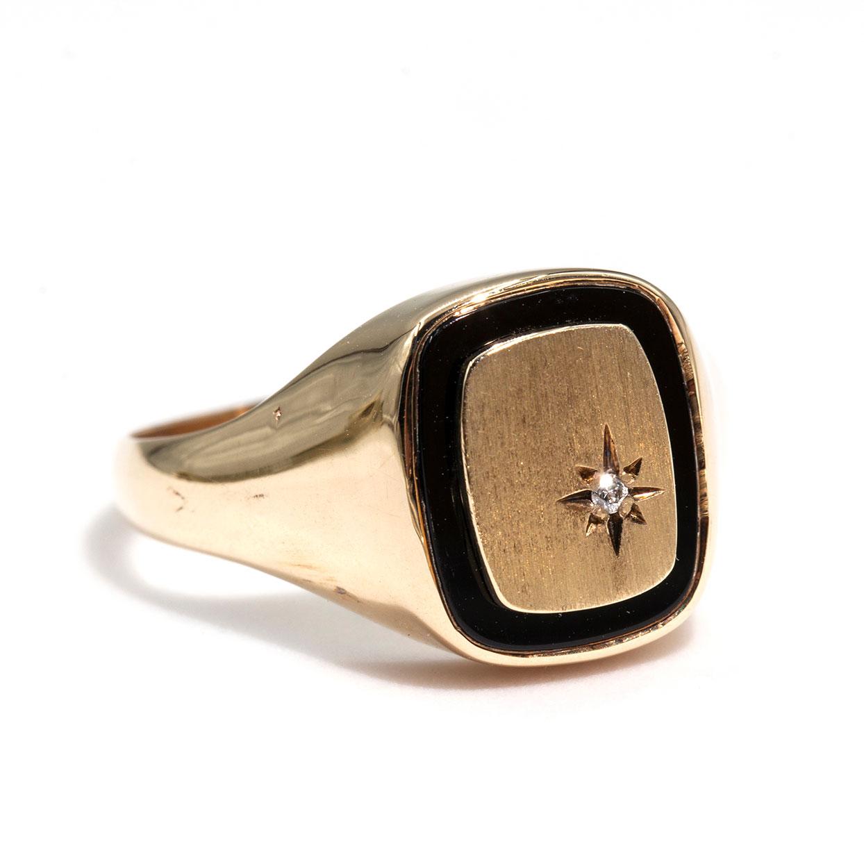 Crafted in 9 carat yellow gold is this handsome vintage mens signet ring featuring a buff top black onyx with a gold plate sitting on top with a star set round brilliant cut diamond. We have named this dapper piece The Riley Ring. The Riley Ring has