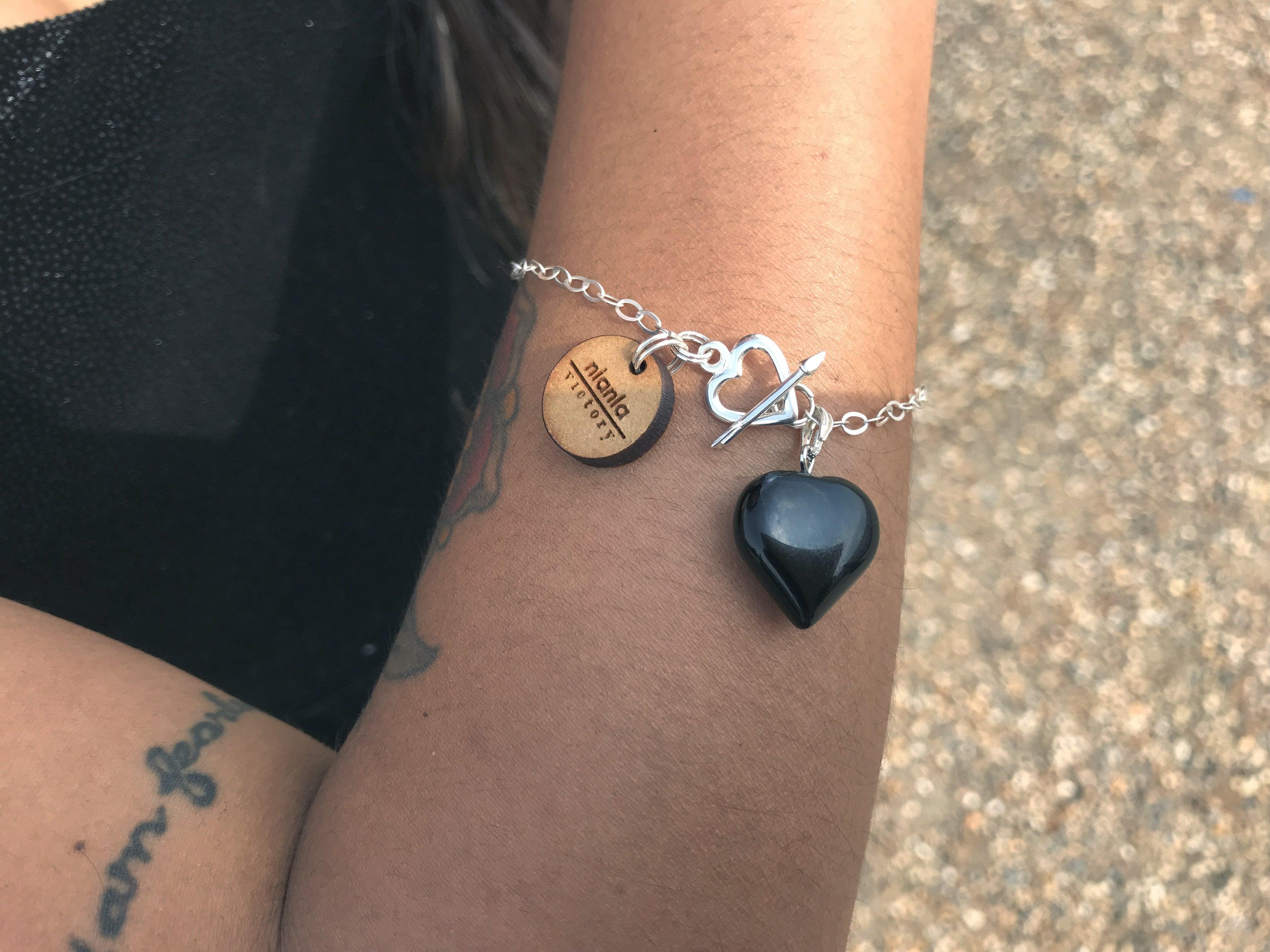 This stunning Black Onyx Bracelet with a Sterling Silver Heart Charm is a must-have addition to your jewelry collection. The black onyx beads are polished to a smooth finish and are accented with a gorgeous sterling silver oval links, making it the