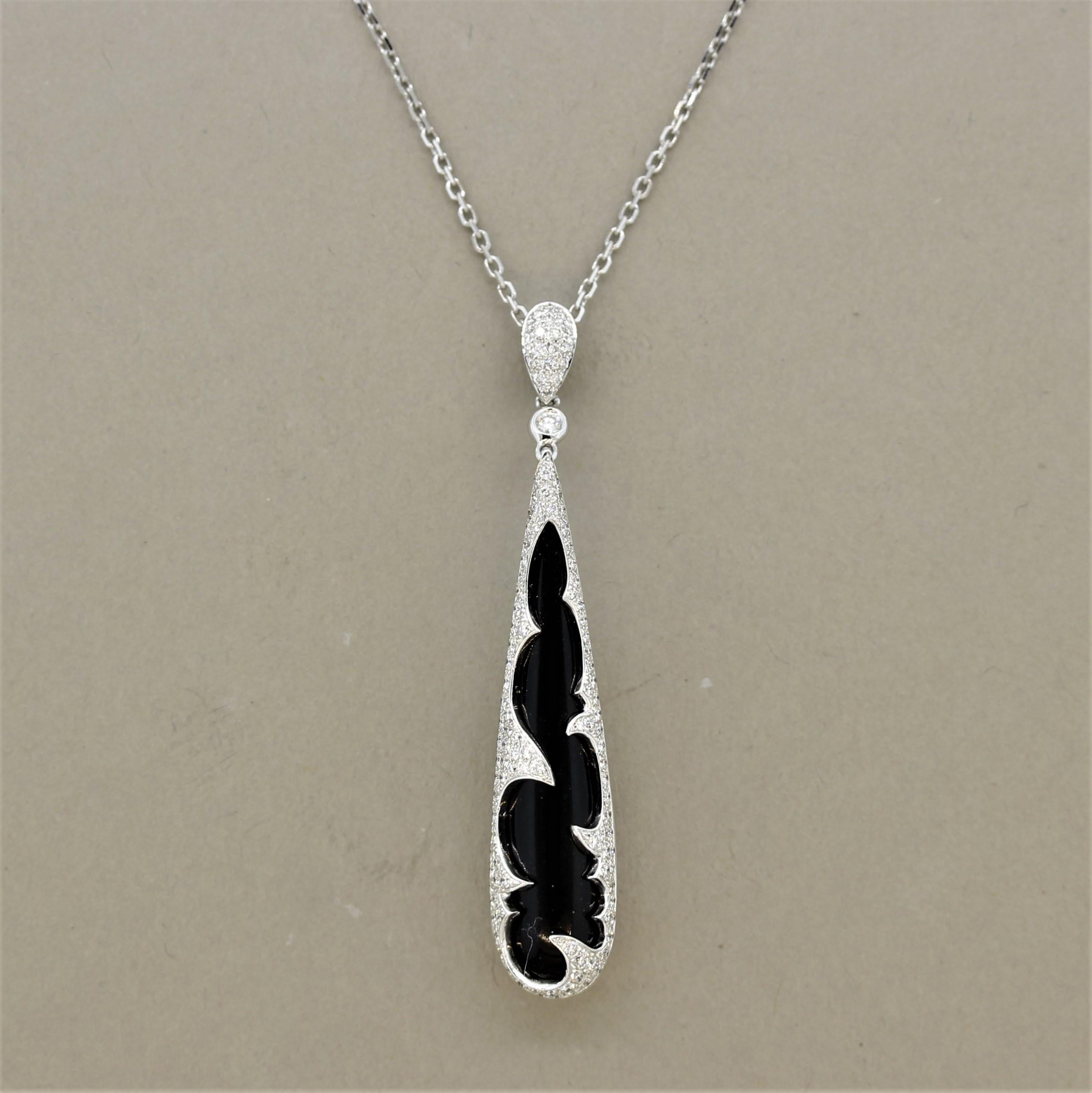 A sleek and sexy pendant featuring a jet-black piece of onyx shaped as a briolette with a bright polish. It is encased in 18k white gold set with 054 carats of bright round brilliant cut diamonds which contrast with the deep black onyx. Made in 18k