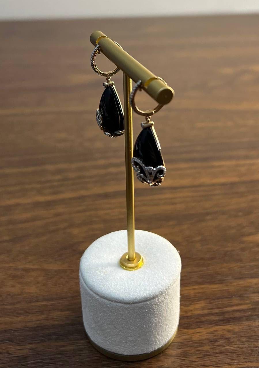 Elegant and sophisticated, these striking drop earrings feature glossy black teardrop black Onyx stones adorned with intricate swirling accents of shimmering white diamonds G/VS Quality . In 18K Karat Rose Gold.