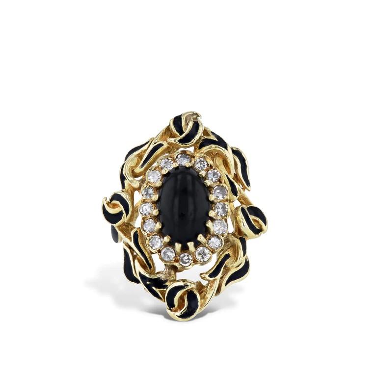 Gracefully crafted from 18 karat yellow gold, this oval black onyx estate ring emanates opulence. It includes 16 single-cut diamonds. Accented with a sleek black enamel finish, crafted circa 1960's, this extraordinary piece is sure to turn heads.