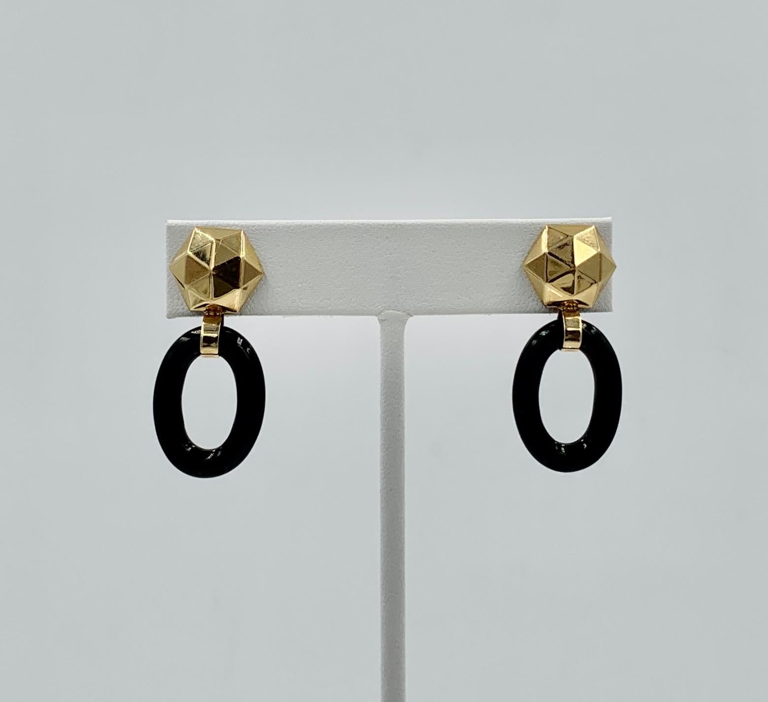 A classic pair of Retro Door Knocker Earrings with oval Black Onyx drops and wonderful pyramidal motif hexagonal tops in 14 Karat Yellow Gold.  These dangle drop earrings have the most wonderful combination of the Black Onyx and the warm 14 Karat