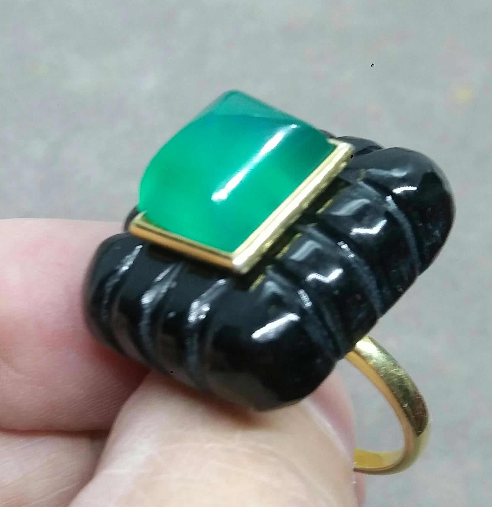 Bague unique avec un grand Onyx noir gravé de forme rectangulaire en L, mesurant 23 mm. x 26 mm x 10mm. et pesant 79 Carats avec une belle Pyramide d'Onyx vert mesurant 10 mm x 12 mm sertie dans un chaton en or jaune 14 kt.  L'or jaune massif est