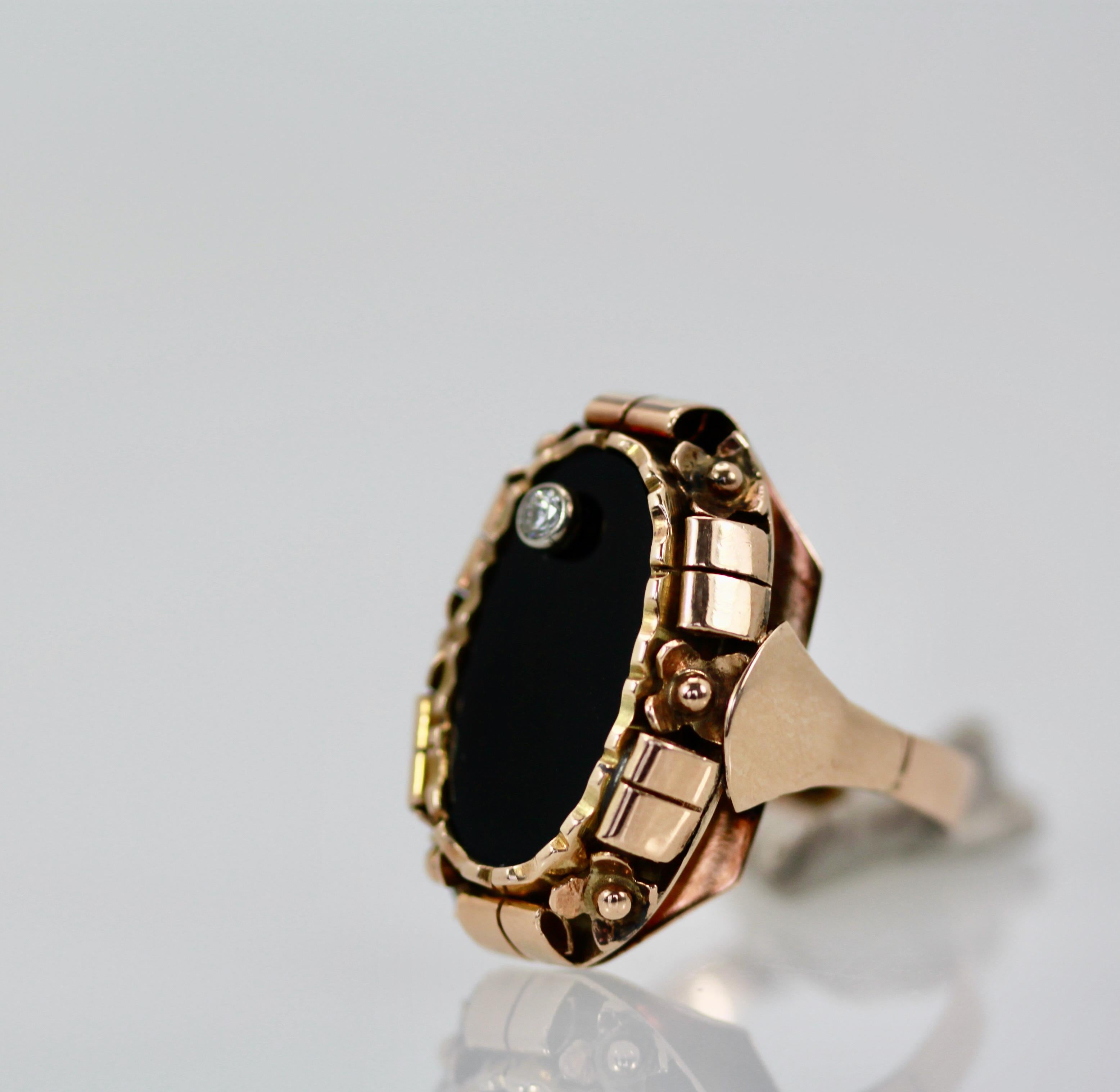 This awesome black onyx ring is set in 14K rose gold.  It is large and covers the finger quit nicely.  It has a small Diamond  set on the top of approximately 0.10 cts.  This ring is from the 1940's and is highly detailed and chase worked,  just