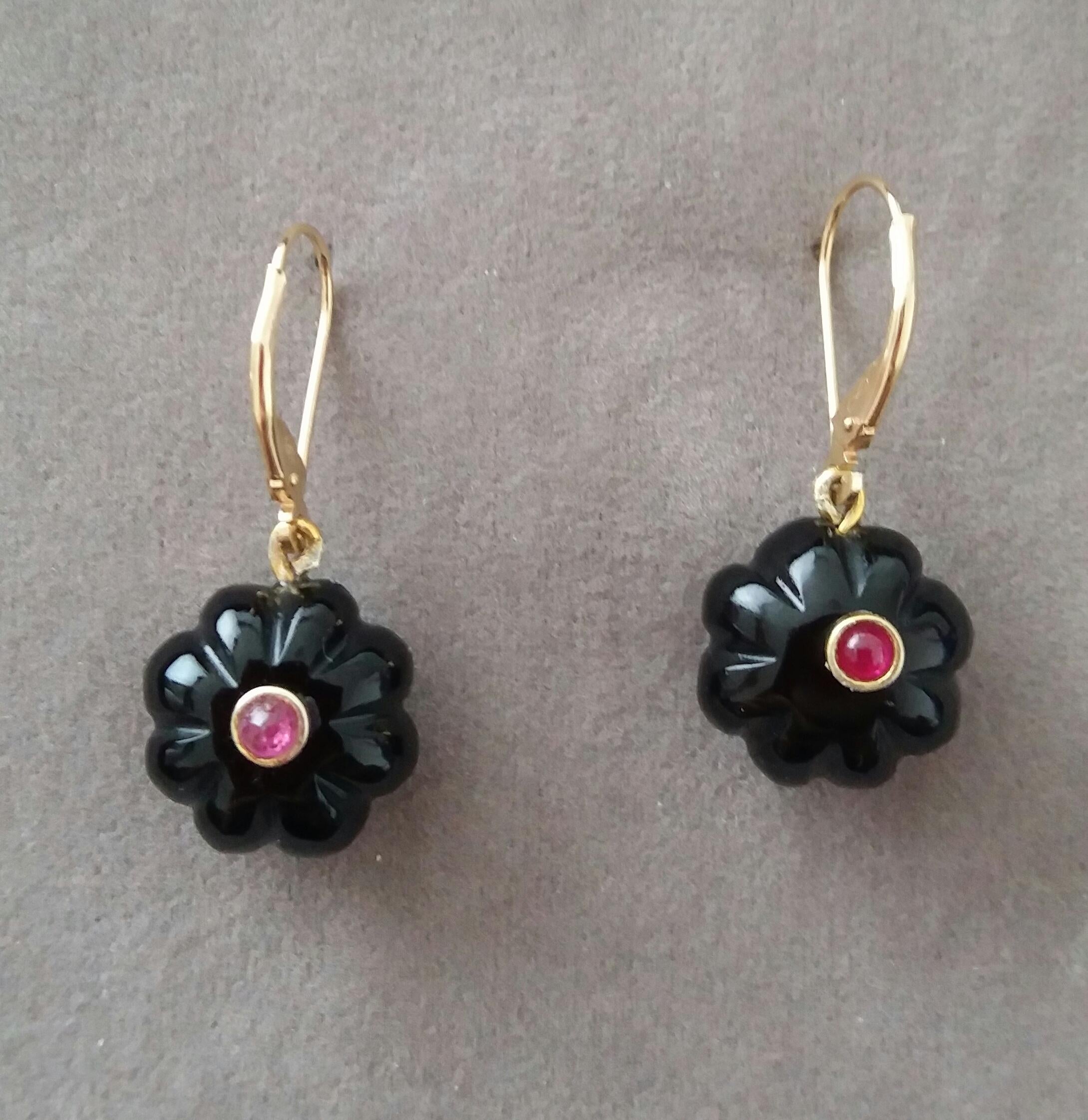 Boucles d'oreilles simples et chics composées de 2 boutons ronds sculptés en onyx noir de 13 mm de diamètre avec un petit cabochon en rubis au centre, suspendus par un clip en or jaune 14 K.

En 1978, notre atelier a démarré en Italie pour fabriquer