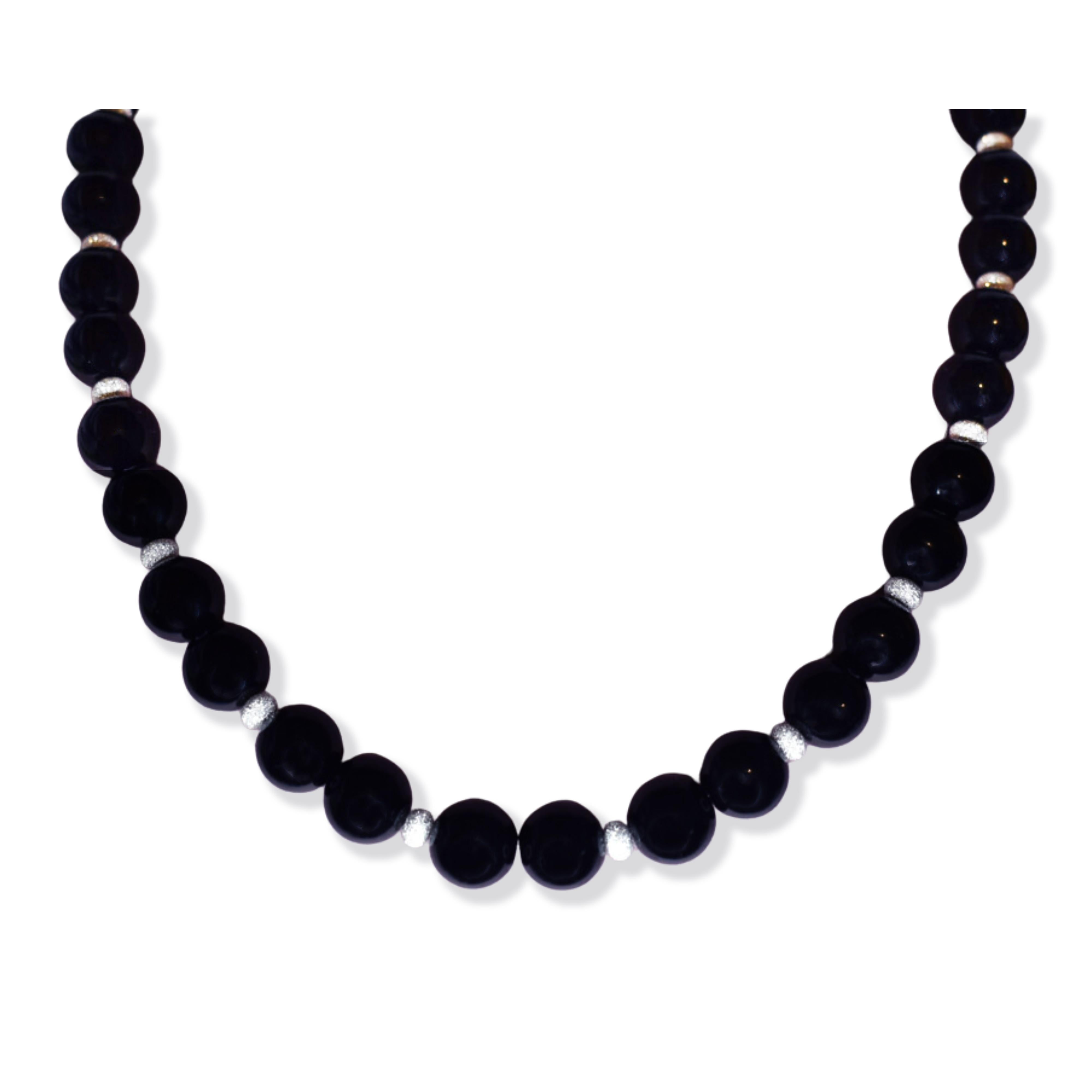 Scopri l'eleganza della nostra collana di perline in onice nero e argento, un pezzo senza tempo che dona raffinatezza e charme a qualsiasi ensemble. Caratterizzata da perle di onice nero lucido, ognuna delle quali brilla di una lucentezza profonda e