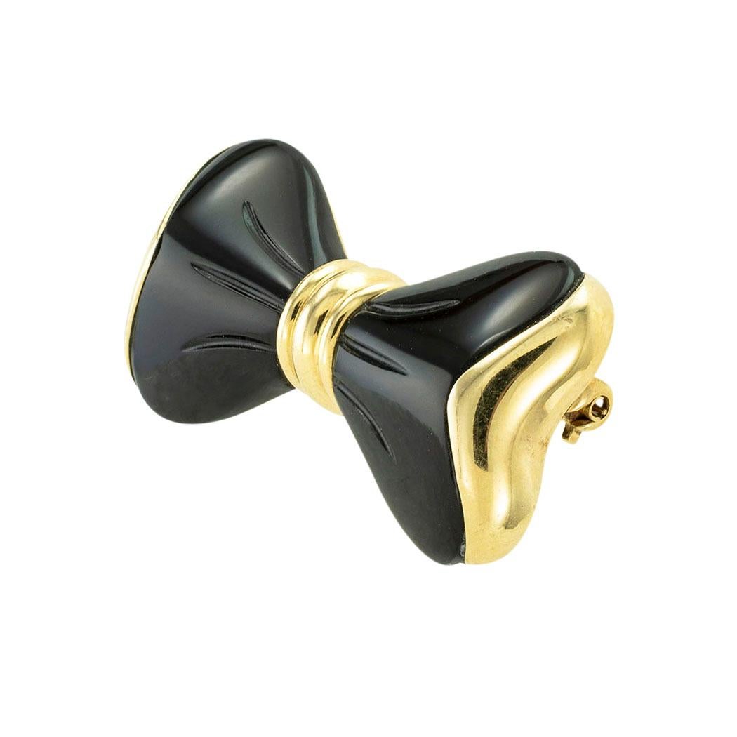 Black onyx and yellow gold bow brooch circa 1970. 

SPECIFICATIONS:

GEMSTONE:  carved black onyx and shaped like a bow.

METAL:  14-karat yellow gold.

WEIGHT:  9.6 grams.

MEASUREMENTS:  approximately 1-3/8” (3.49 cm) by 3/4” (1.90 cm)