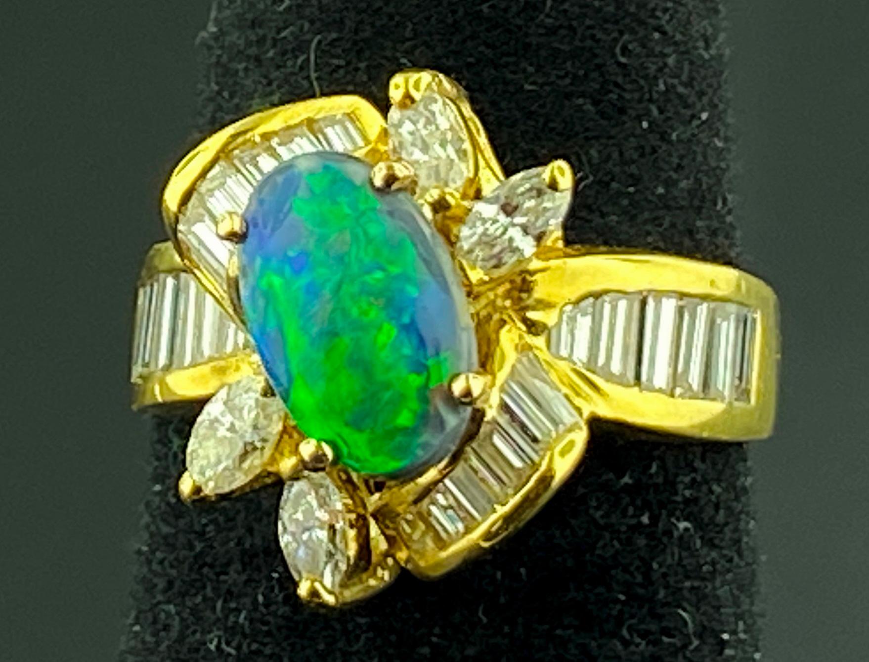 Set in 18 karat yellow gold is an Oval shaped 1.25 carat Black Opal with 4 marquise cut diamonds with a weight of 0.50 carats and 18 baguette cut diamonds with a weight of 0.50 carats, total diamond weight of 1.00 carats.  Color is G, Clarity is VS.