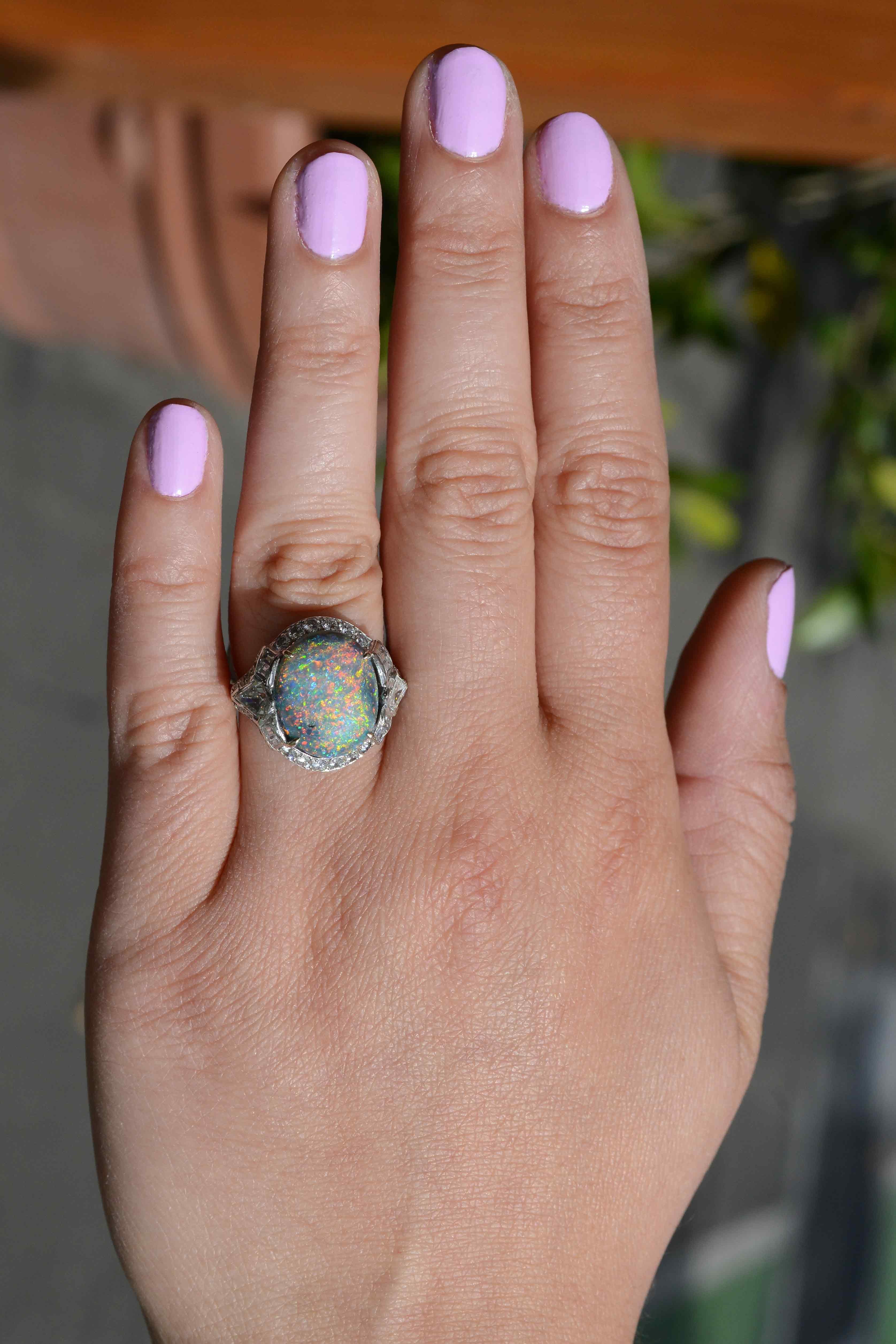 A dramatic dome cocktail ring, this platinum Art Deco masterpiece is truly rare. Hailed for their unusual and stunning beauty, black opals are the rarest and highly sought after gemstones of their kind. The most exceptional of all, such as this 6.76