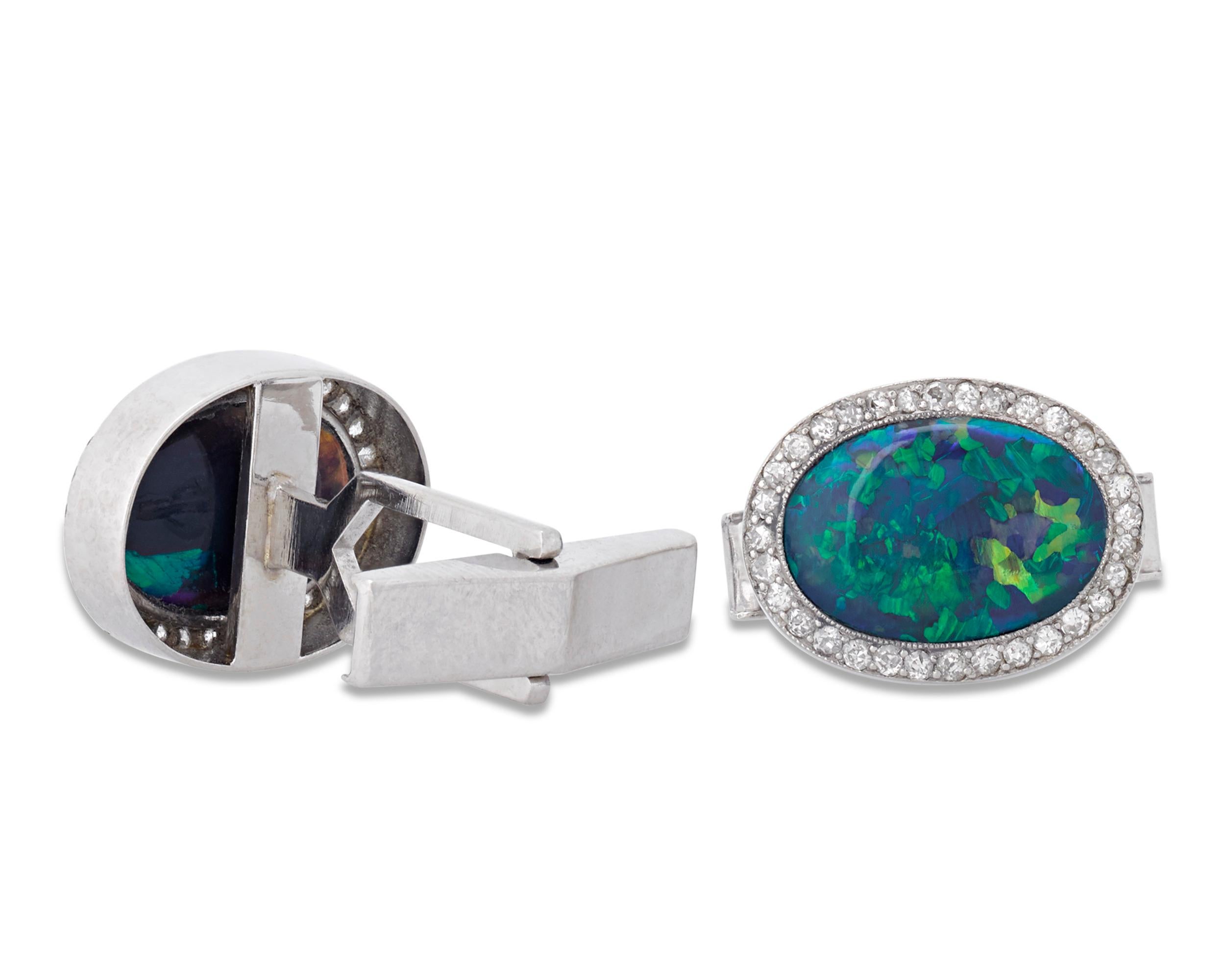 The rare black opals set in these impressive gentleman's cufflinks display an impressive range of iridescent blue and green hues. The remarkable color of the gems, which total approximately 7.00 carats, is perfectly accented by a halo of pavé-set