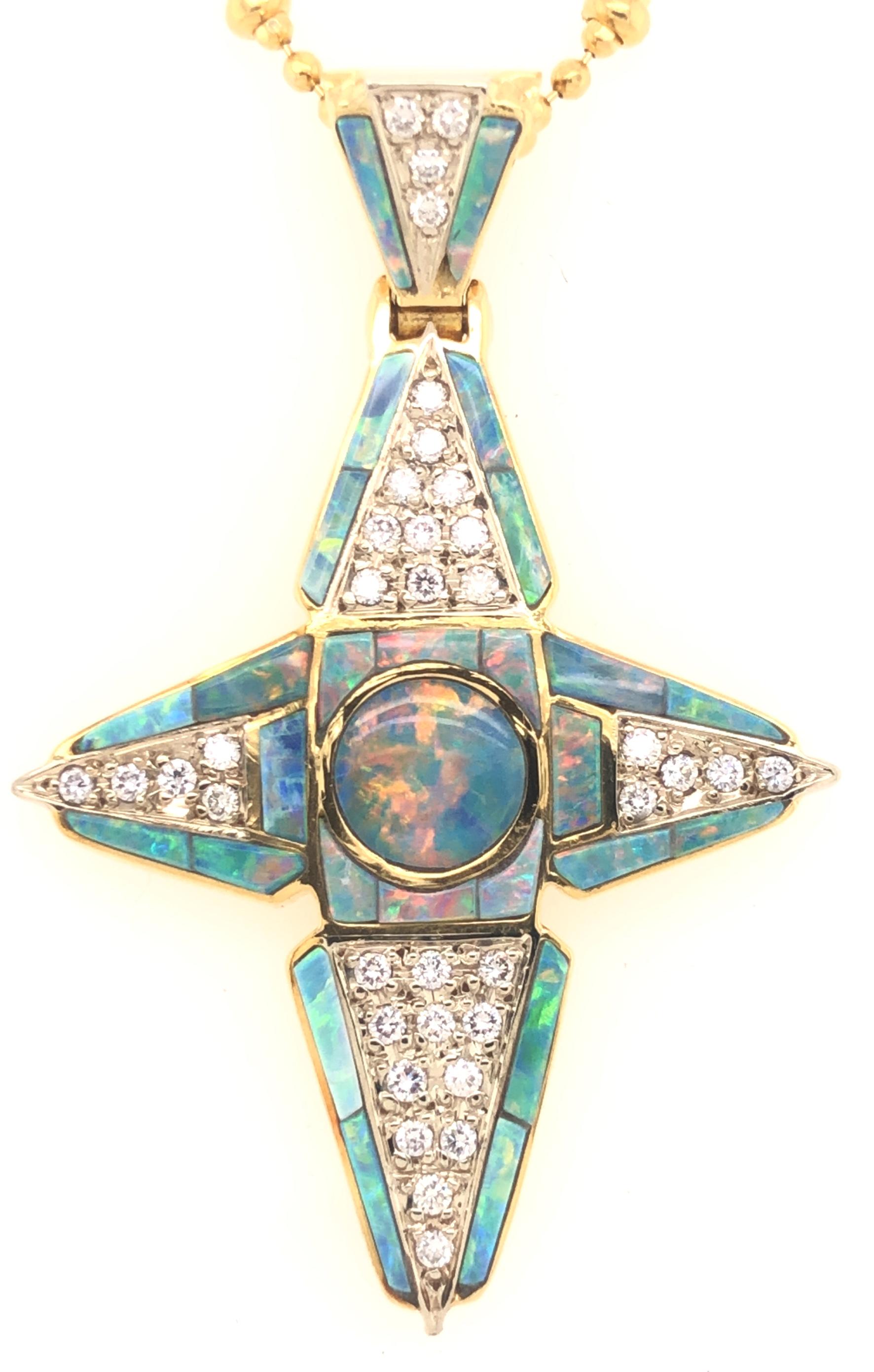 One of a kind design crafted in 18k yellow gold. This cross pendant is set with natural black opal gemstones with diamond accents. The pendant shows one solitary black opal gemstone in the center that displays amazing play of color with flashes of