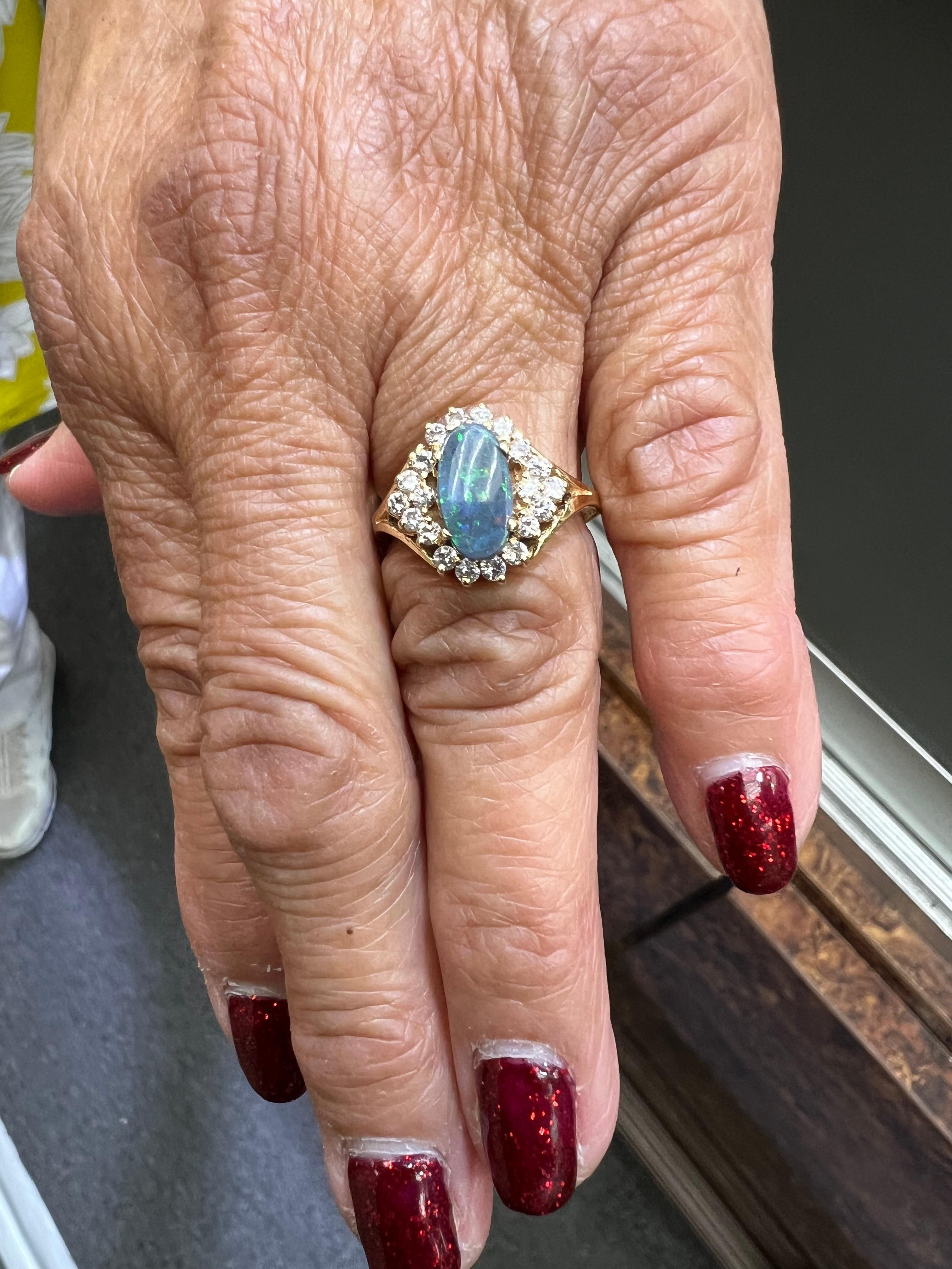 Black Opal Diamond Cluster 14k Yellow Gold Ring, circa 1990s.

The Black Opal Diamond 14k Yellow Gold Cluster Ring was made in the 1990s.  And it features an oblong cut oval Black Opal with primarily blue and green flashes.  The opal is surrounded
