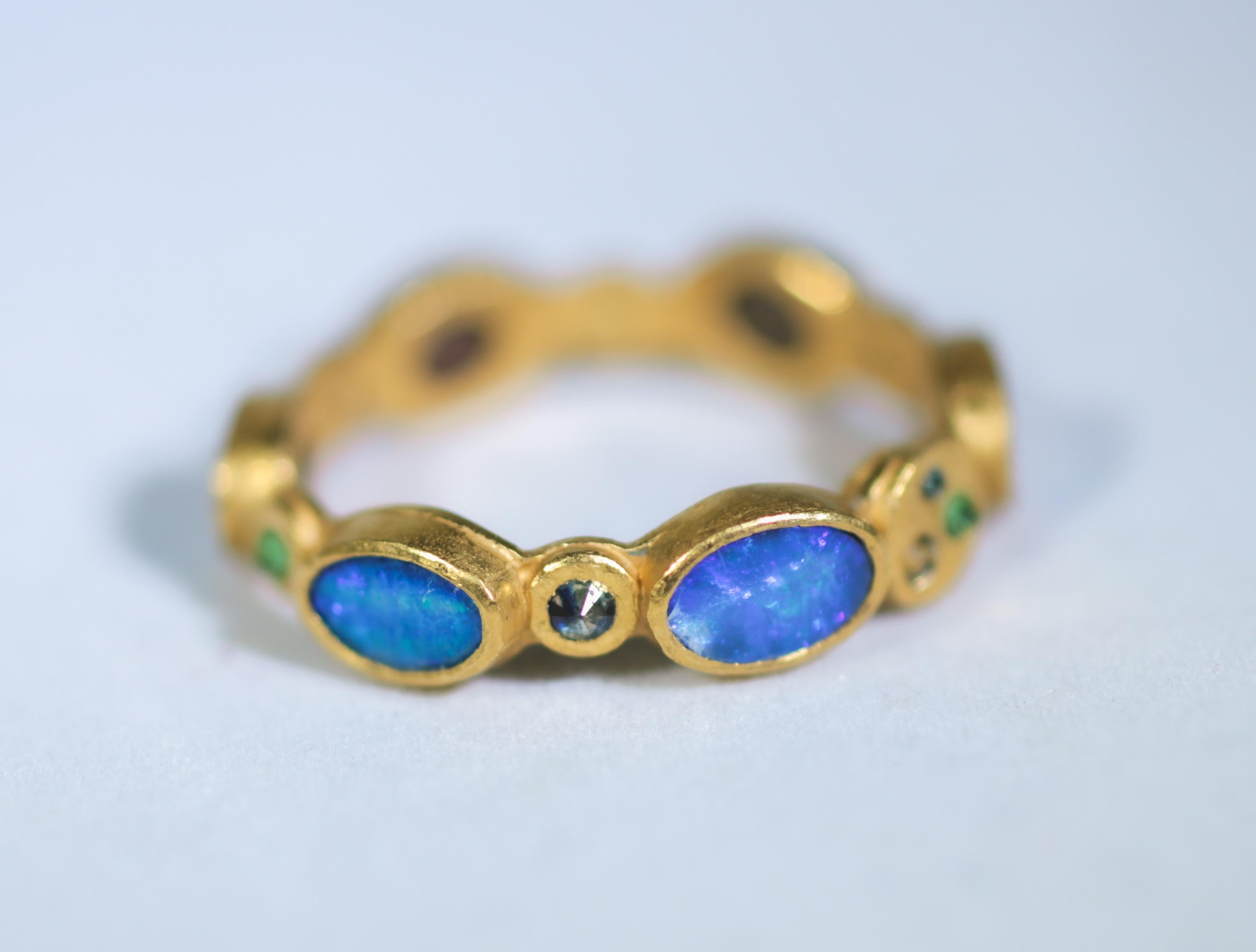 22K gold fashion band ring. Rich and exotic Black Opals are bezels set in solid 22k yellow gold and accented with color diamonds, sapphires, and Tsavorite garnets creating a bright and interesting conversation piece. We love using opals in our