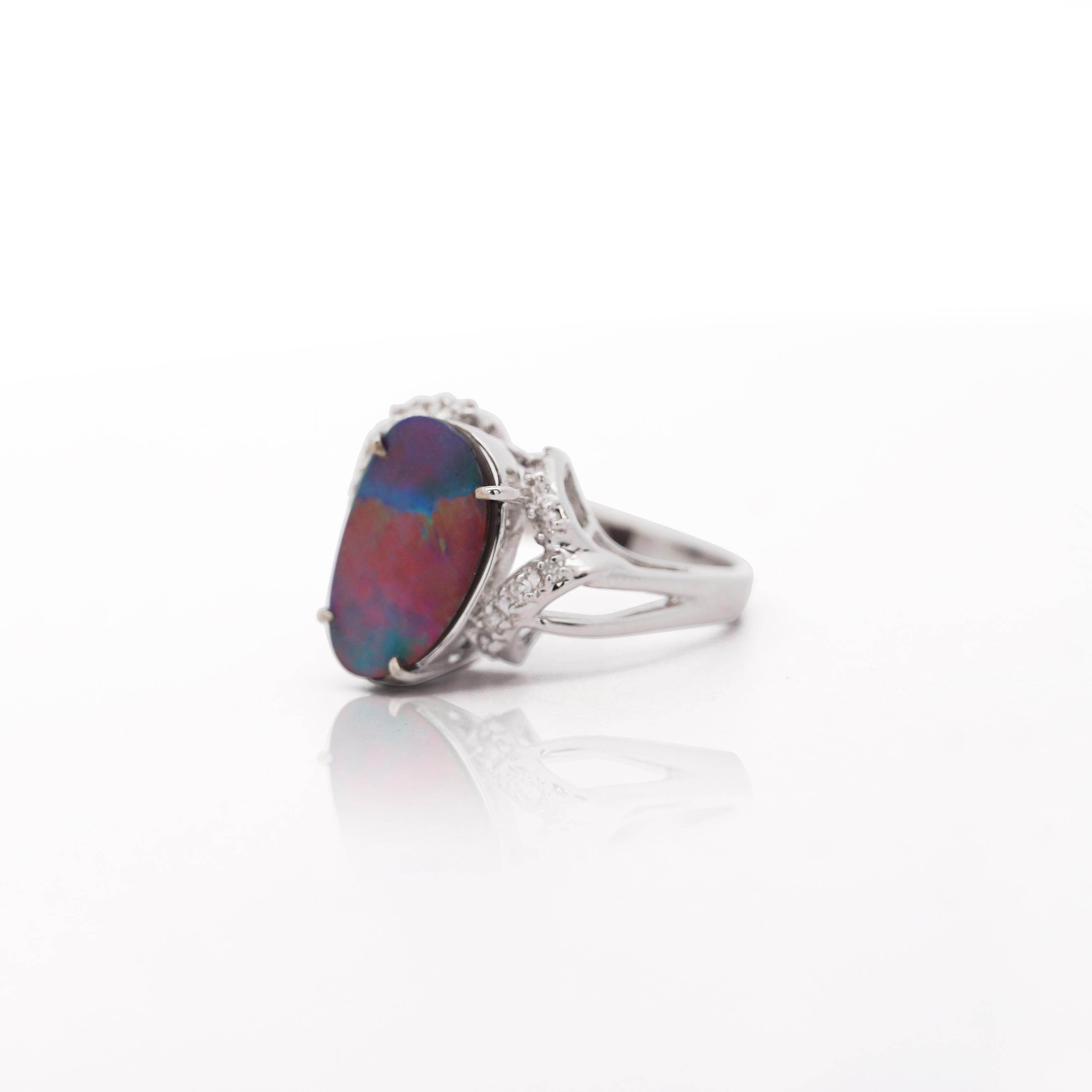 Anello con doppietta di opale nero e diamanti con doppietta di opale ovale di 15,2 x 9,2 mm con vibranti giochi di colore blu, rosso e verde, impreziosita da 0,20 carati di diamanti con design a gambo ritorto in oro bianco 14K. Anello misura 7,5,