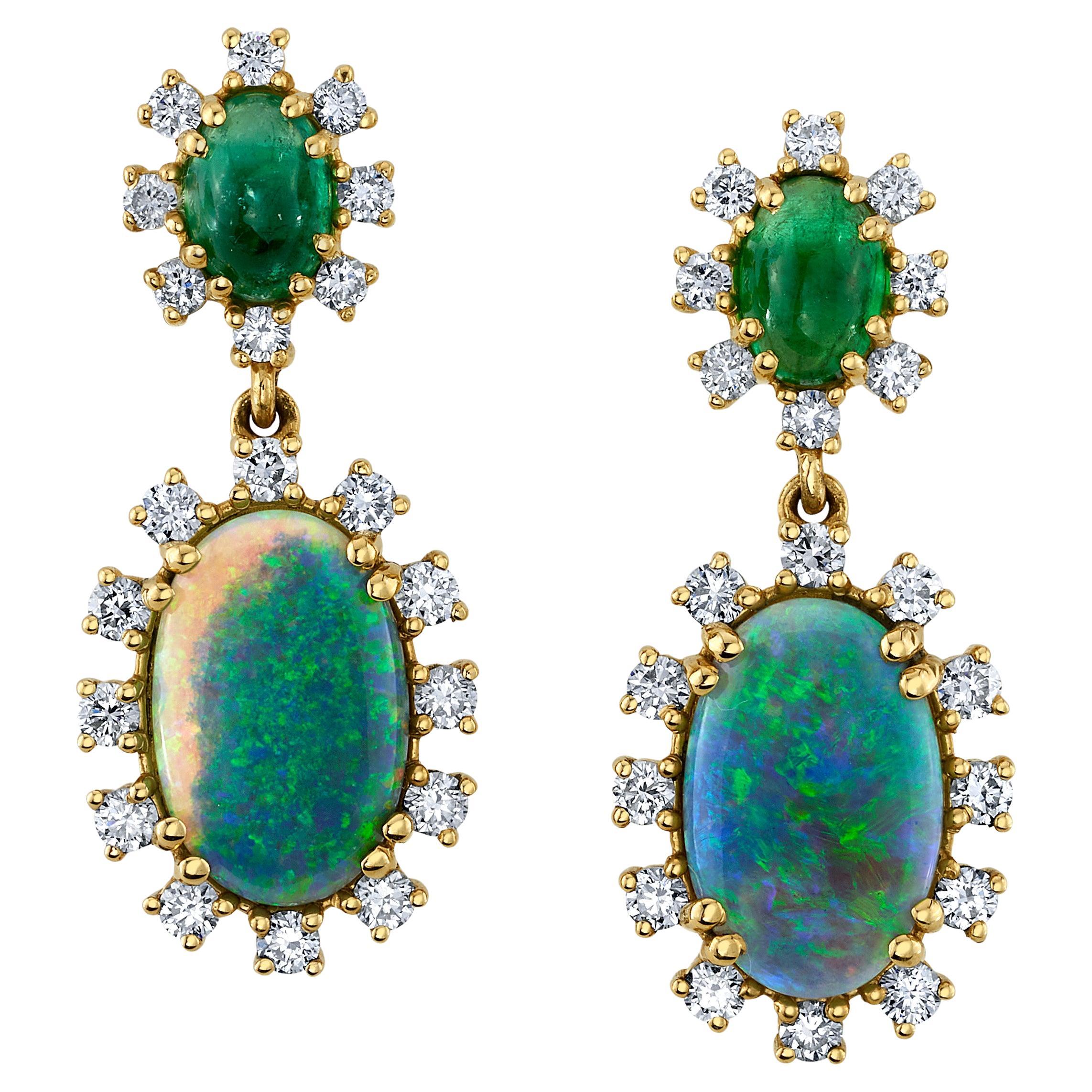These black opal and emerald earrings will elevate any outfit with elegance and style! A beautifully matched pair of black opals are framed with sparking diamonds in these handcrafted 18k yellow gold earrings. The opals dangle beneath a pair of