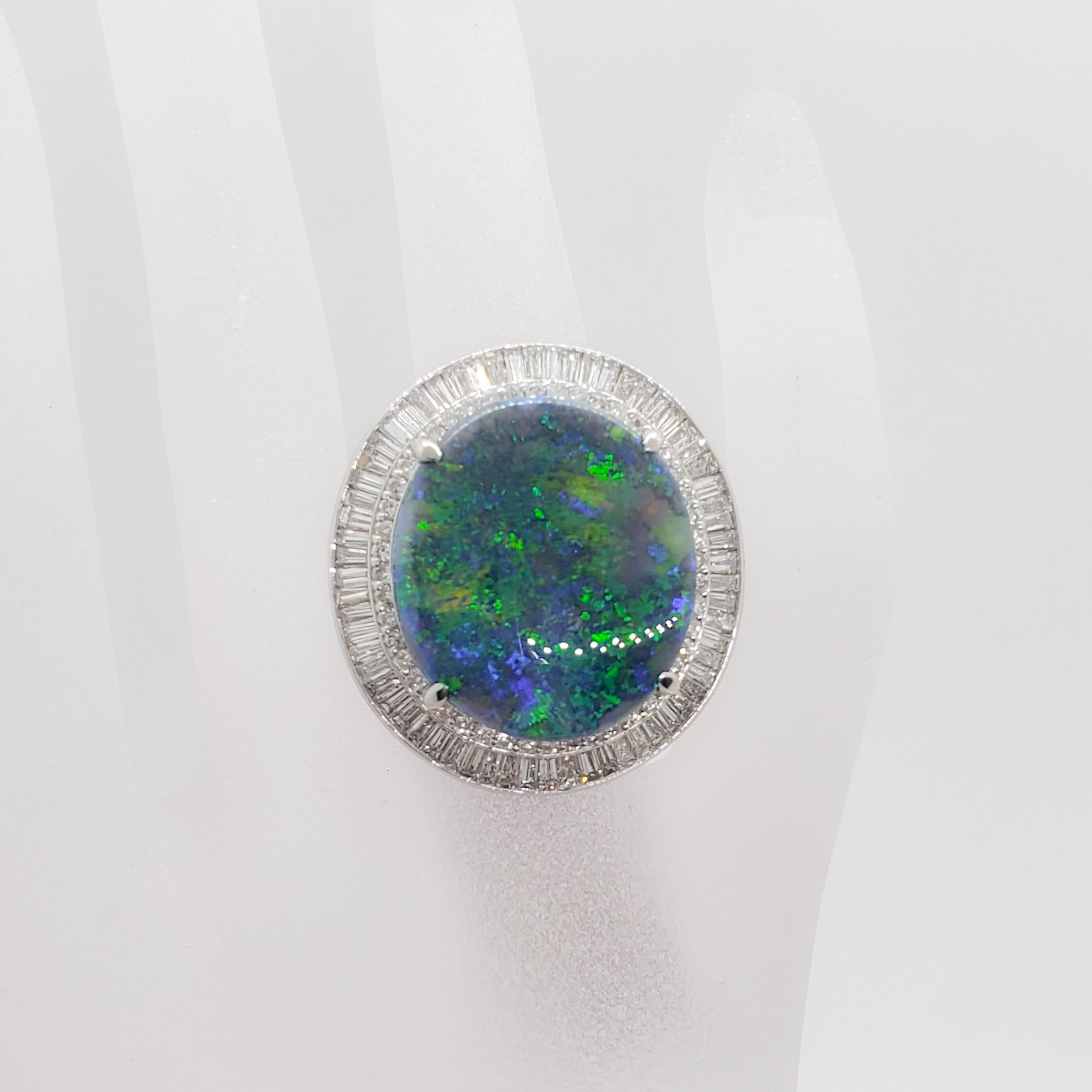 This estate black opal oval ring is stunning!  Showcasing a 15.49 ct black opal oval with gorgeous greens and blues along with 3.56 cts of good quality, white, and bright diamond rounds and baguettes.  Handmade mounting in platinum size 6.25. 