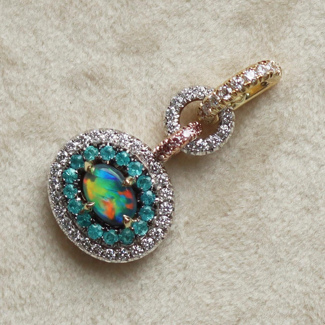 This one of a kind double halo pendant is handmade in Belgium the traditional way, by jewelry artist Joke Quick,  ( no casting or printing envolved) in 18 K Rose, yellow & white gold and is hand set with a Lightning Ridge Black Opal centerstone,