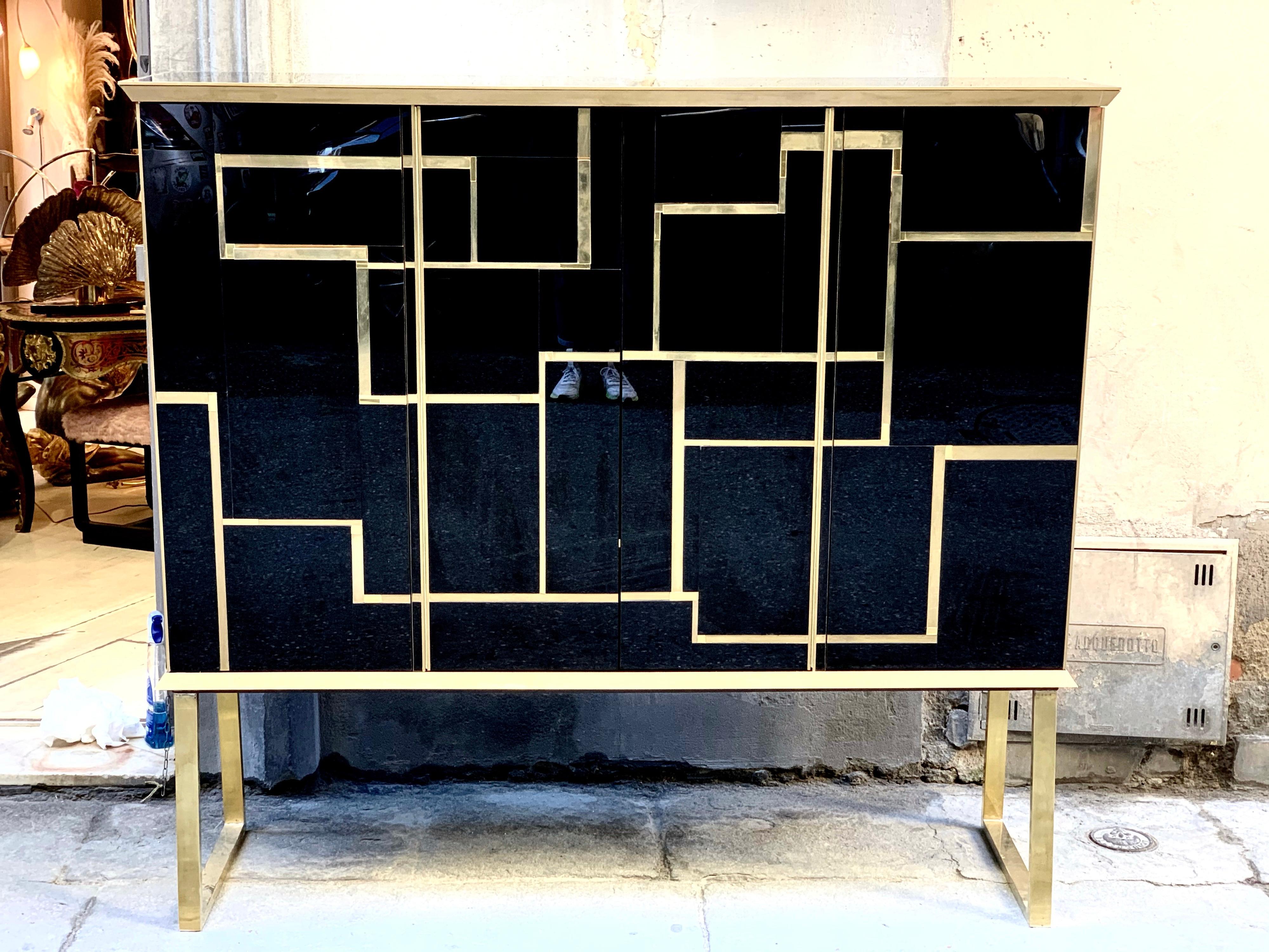 Black opaline glass big cabinet with brass and gold opaline glass geometric inserts.
The cabinet has brass handles and legs, 4 doors with shelves inside. 
 