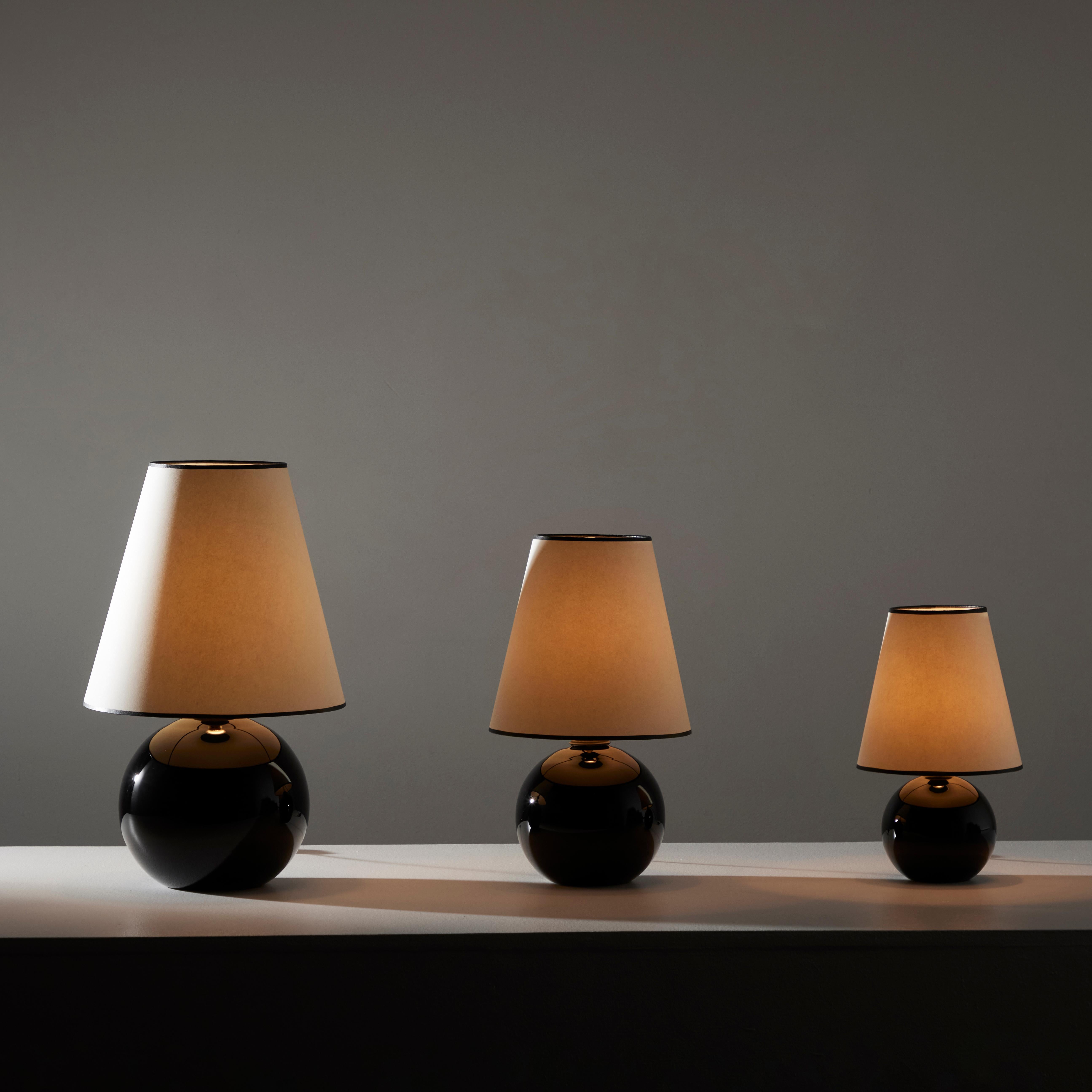 Satz schwarzer Opalintischlampen von Jacques Adnet. Entworfen und hergestellt in Frankreich, ca. 1940er Jahre. Schwarzer opalfarbener Kugelsockel mit einem neu gefertigten Leinenschirm. Jede Lampe enthält eine europäische B22-Bajonettfassung, die