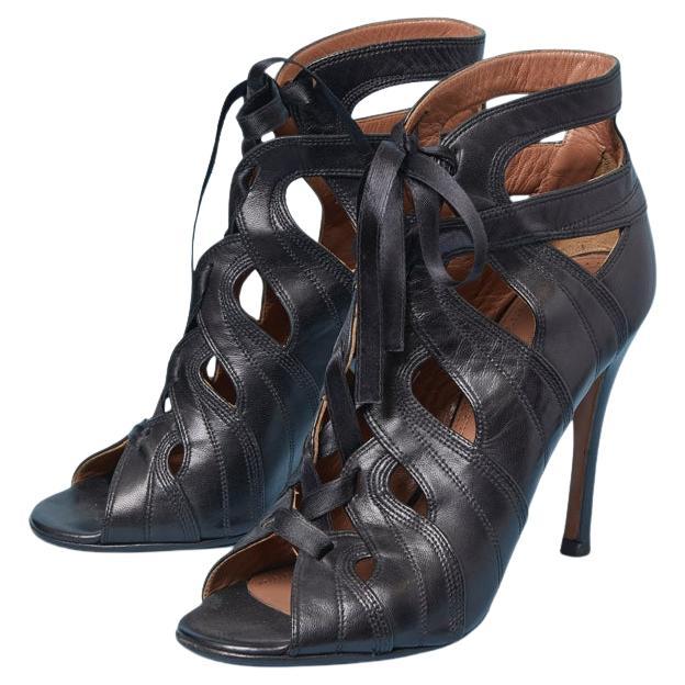 Sandalo nero in pelle con punta aperta e lacci a nastro sul davanti ALAIA in vendita