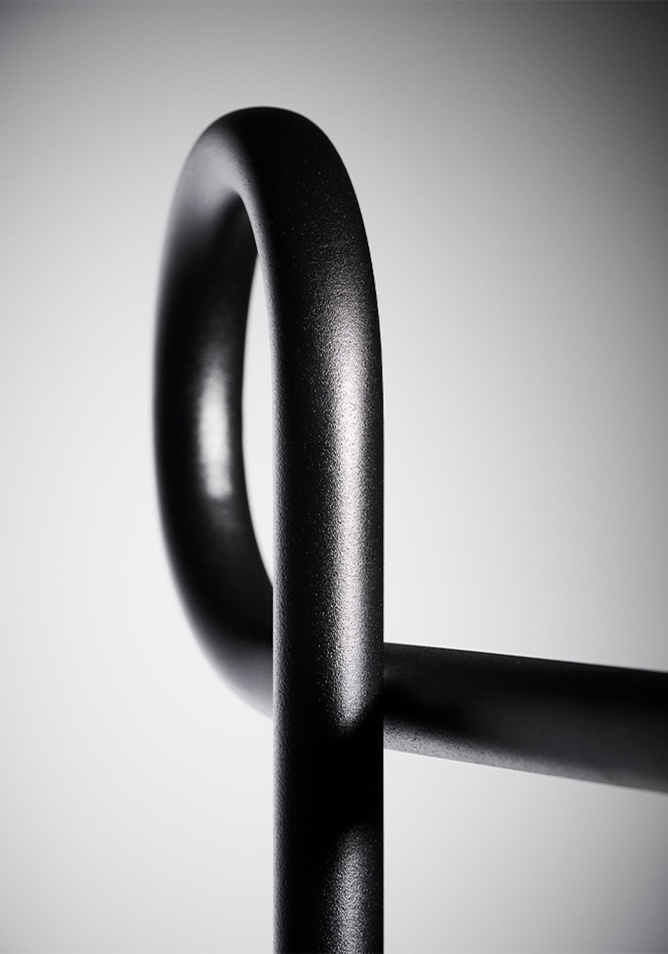 Schlicht und raffiniert zugleich: Der Garderobenständer SLINGA von Drecker Design macht einen Looping und endet oben mit einer kleinen Kugel als Endpunkt. 