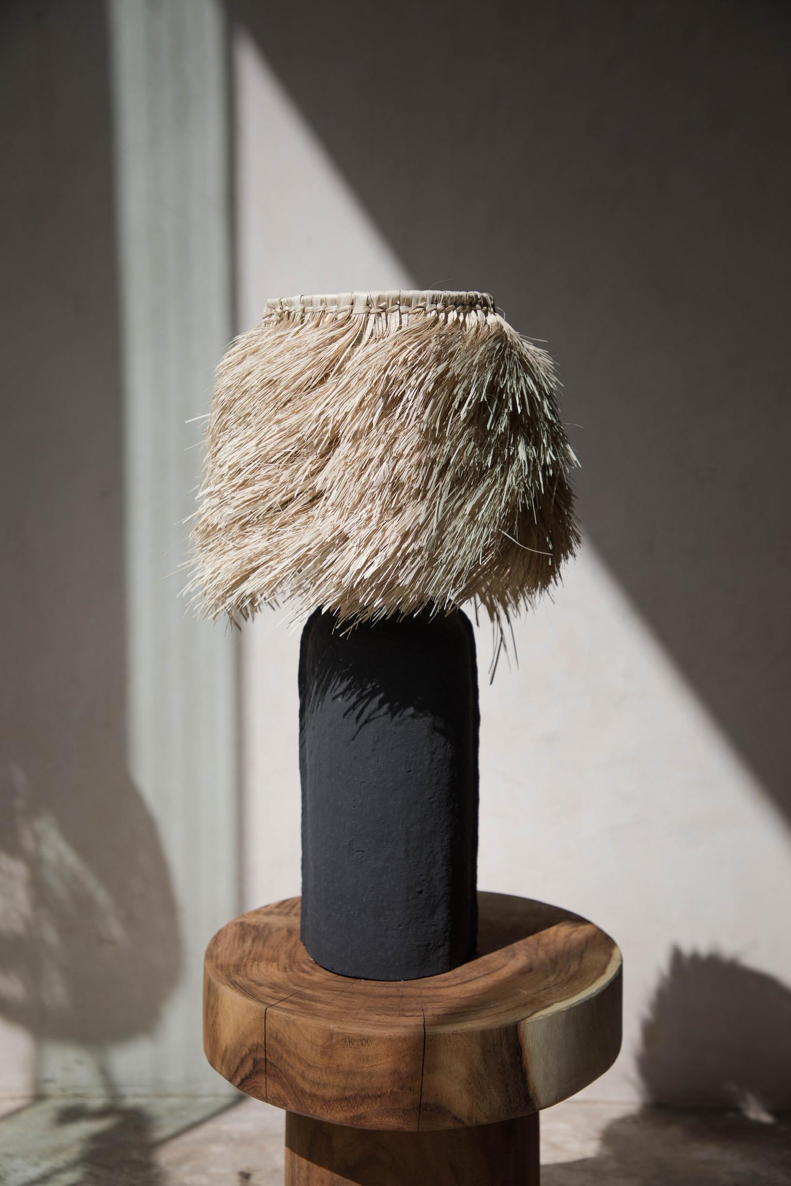 Schwarze Original L3 Holztischlampe von Daniel Orozco
MATERIAL: Holz, Papier.
Abmessungen: D 20 x H 57 cm
Erhältlich in schwarzer oder weißer Ausführung.

Tischlampe aus Holz, schwarzes oder weißes Papier mit Palmenschirm. Handgefertigt von