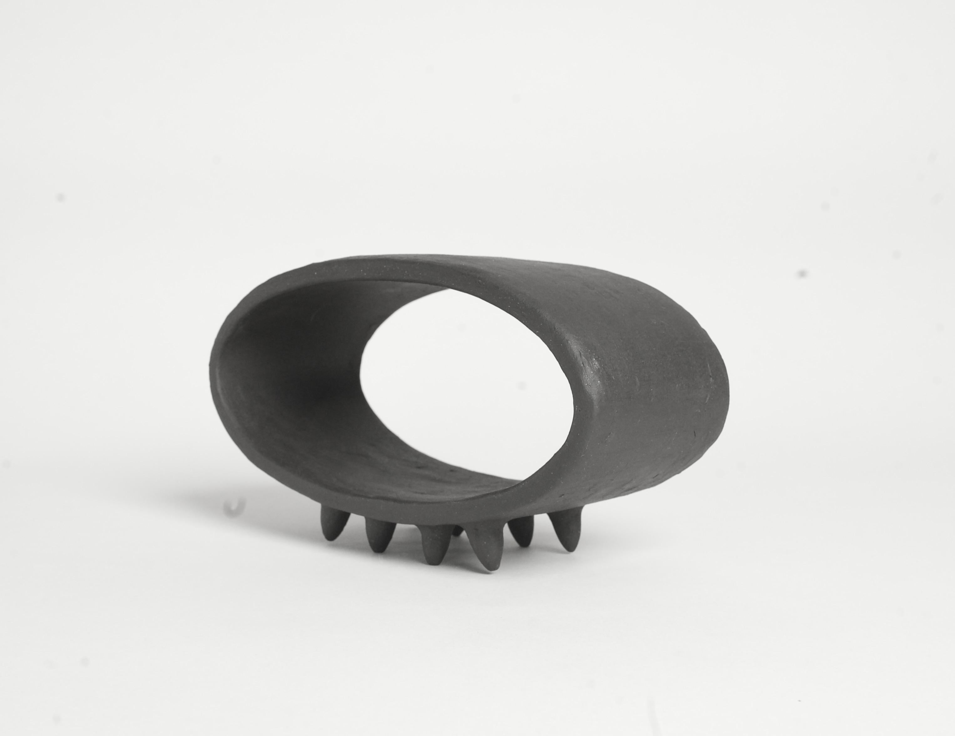 Organique Sculpture ovale en céramique noire avec 2 rangées de petits pieds pointus en vente