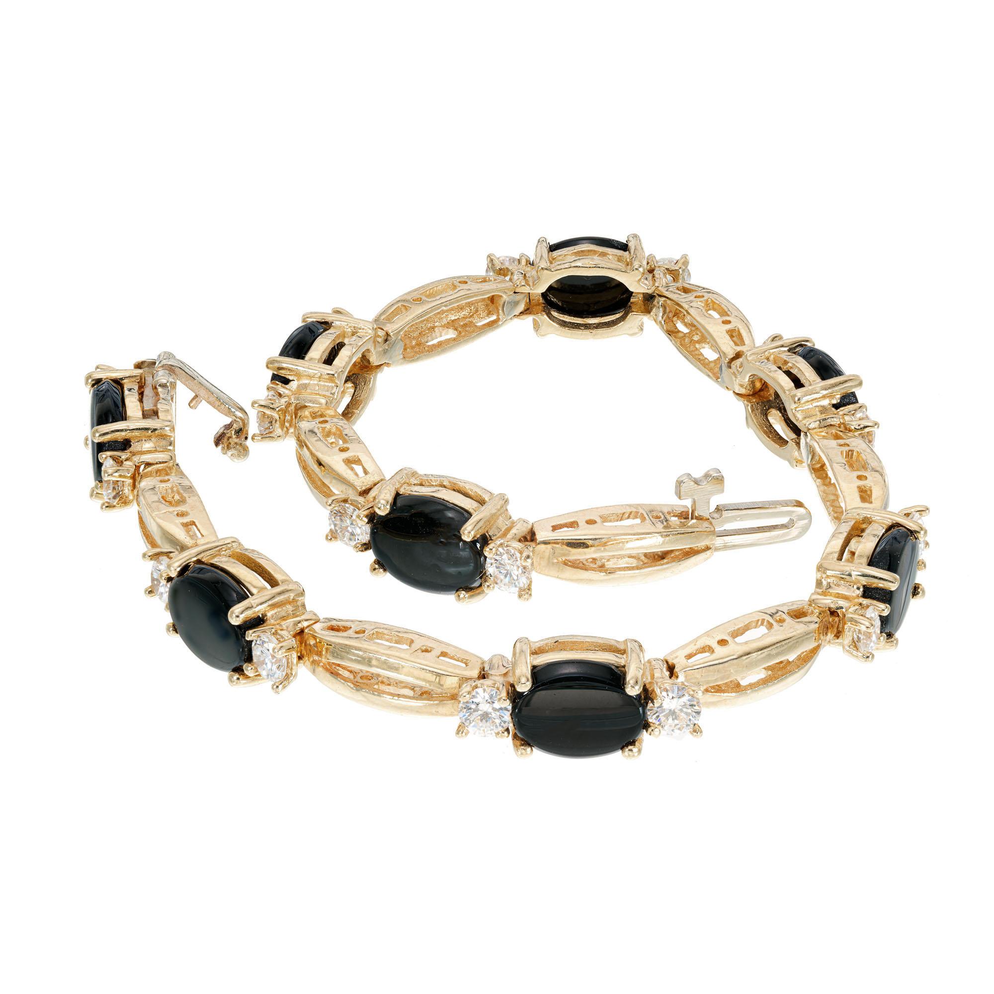 1960's Onyx and diamond link bracelet. 8 oval onyx with 16 round diamonds set in 14k yellow gold. Hidden catch with underside safety.  6.5 inches in length. 

16 round diamonds approx. total weight 1.30cts, G, VS
8 oval onyx 6 x 8mm
14k Yellow