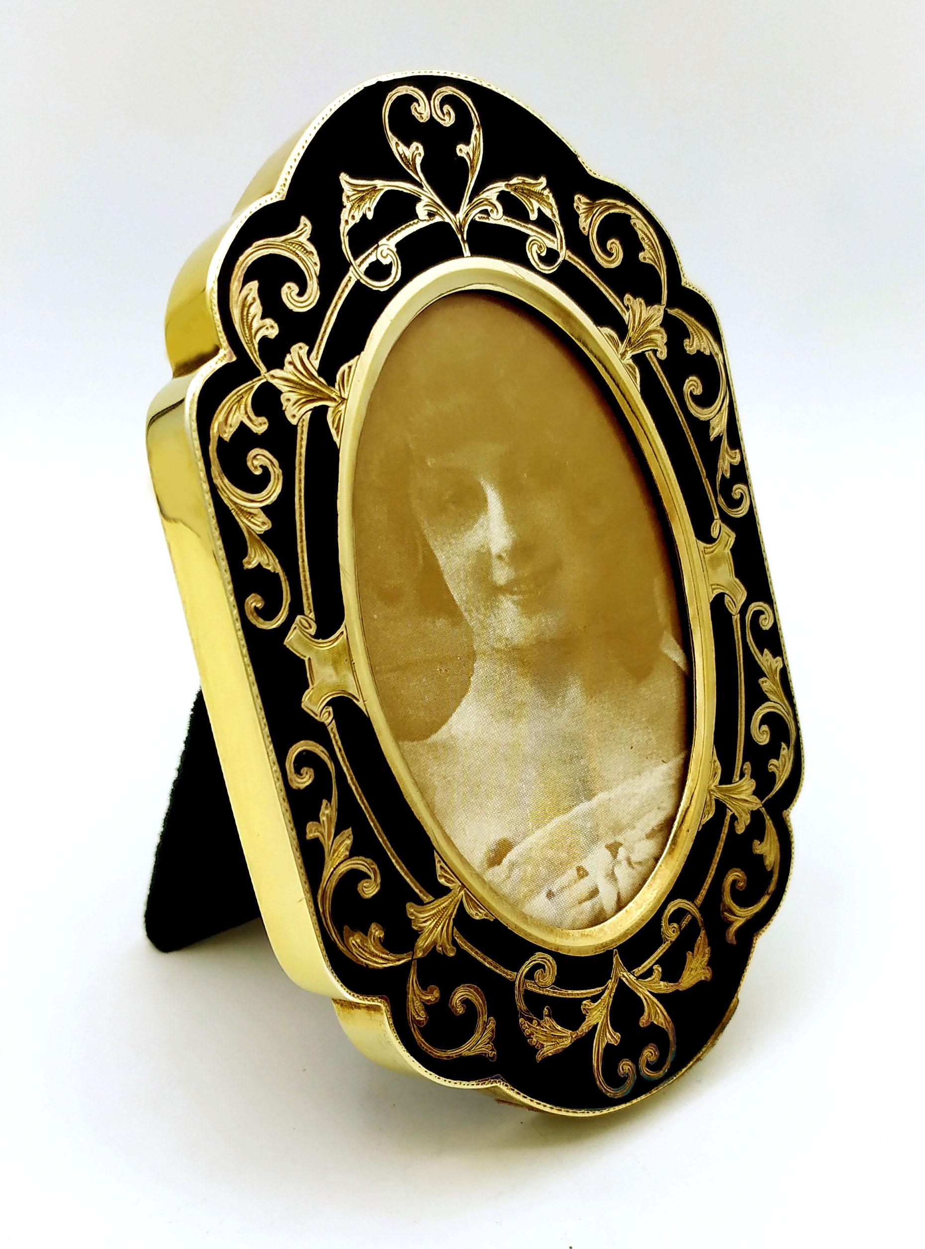 Oval photograph frame, shaped edge in sterling silver 925/1000 gold plated with fine hand engraving, interspersed with black fired enamel in Baroque style. External cm. 7.4 x 11.3. Weight gr. 86. Designed by Franco Salimbeni in 1982 on inspiration