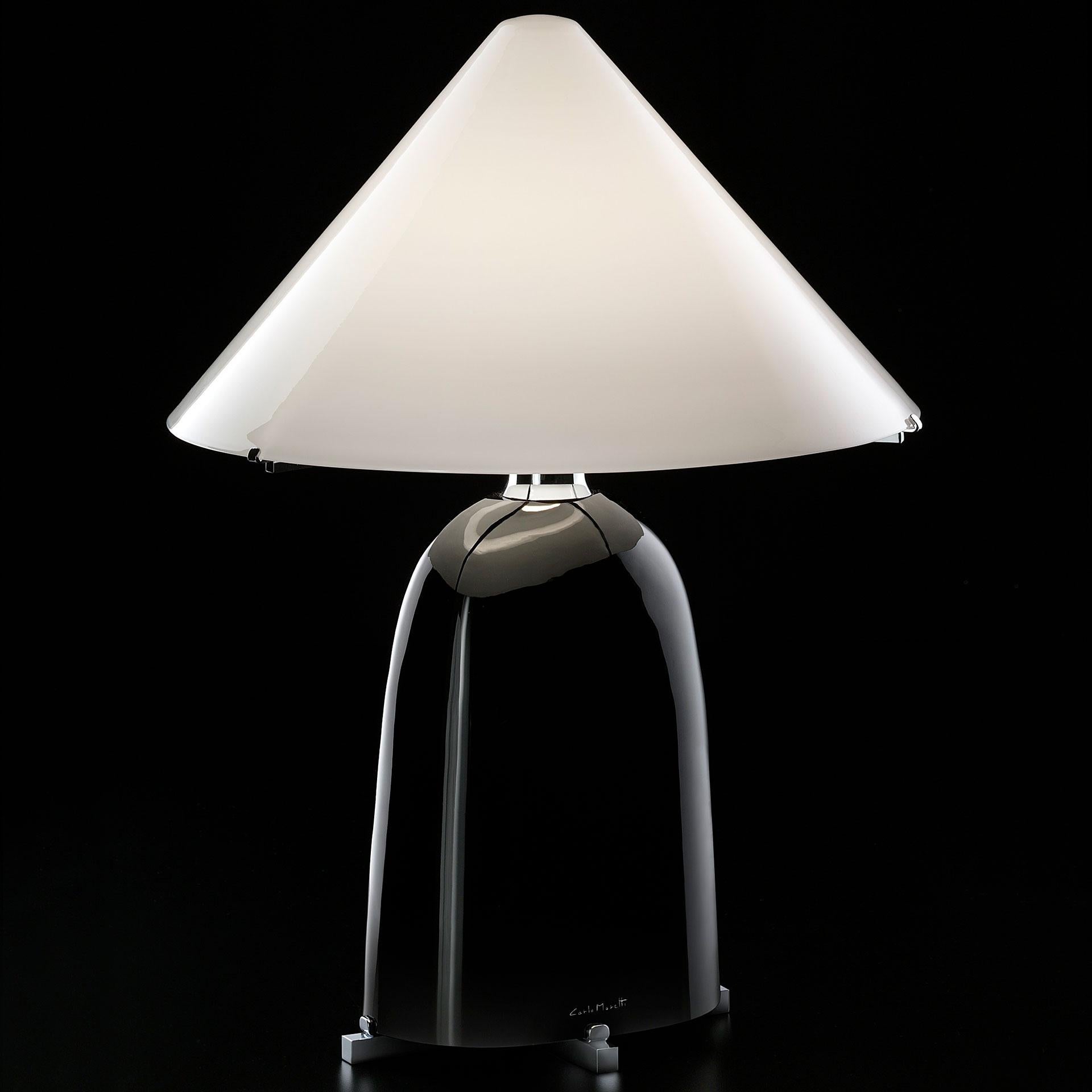 Chosen as one of Architectural Digest “best new lights, 2015”, Ovale is a table lamp of black mouth blown Murano glass and mouth blown Murano white opaline glass shade mounted on gilded metal. The lamp was designed in 1983 by Carlo Moretti.