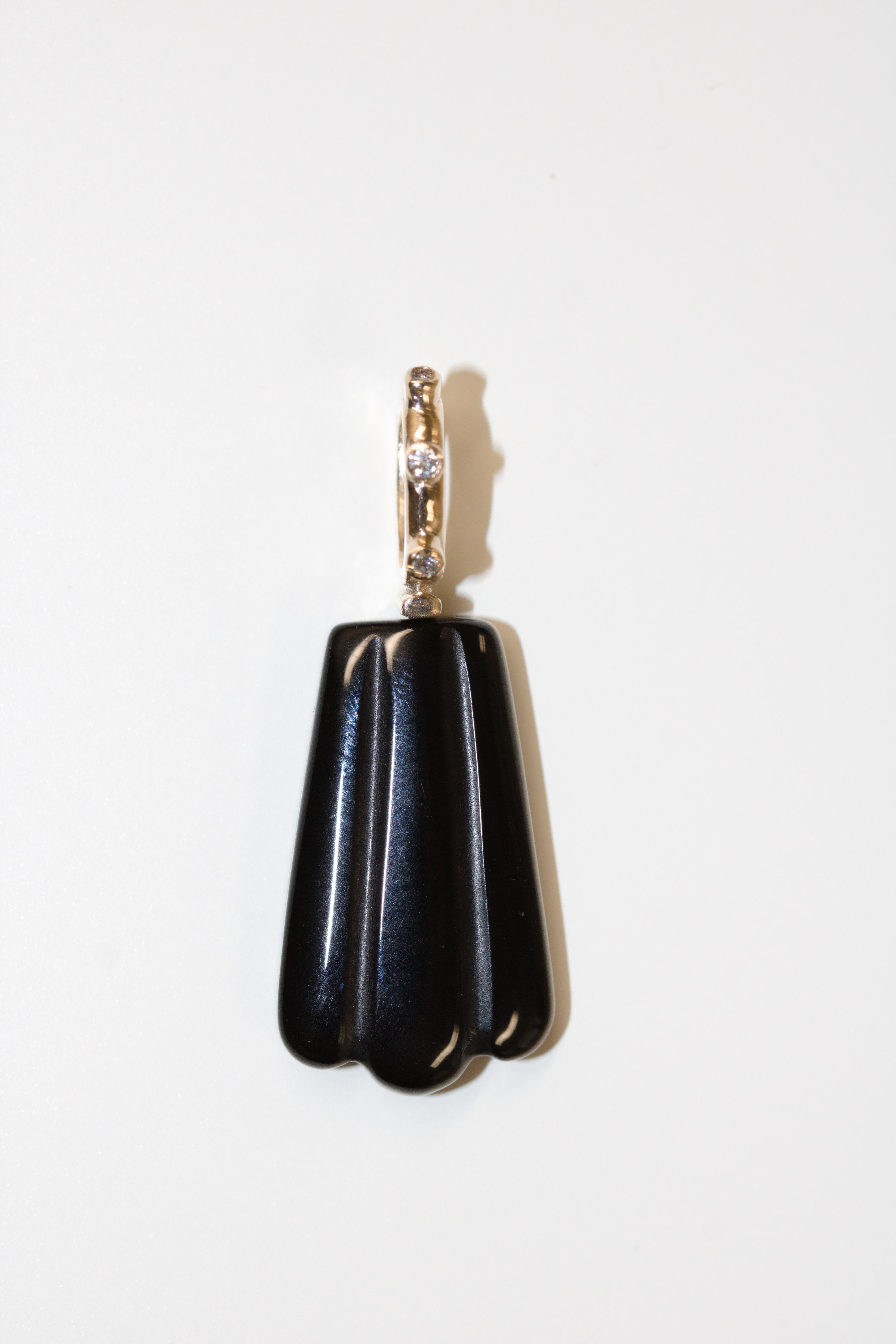 This pendant necklace is a one of a kind creation from the London based jewellery brand Skomer Studio.

Crafted by hand in the designer's studio, this black onyx and diamond shell pendant has been made using recycled 9kt gold and black silk rope. As