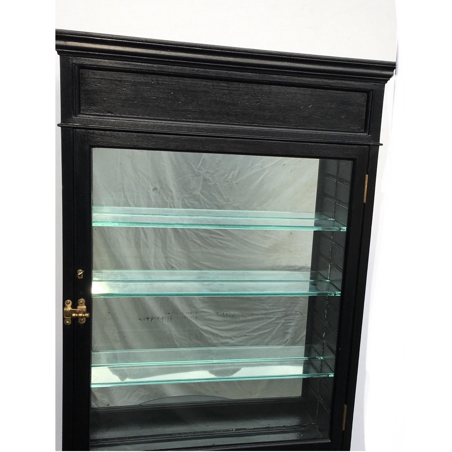 Black wall or freestanding curios display case, English, 1930s.

Painted Black gloss wood and glass wall mounted or free standing curios, display case or Bathroom cabinet. This would once have been a shop display case.
Constructed with aged