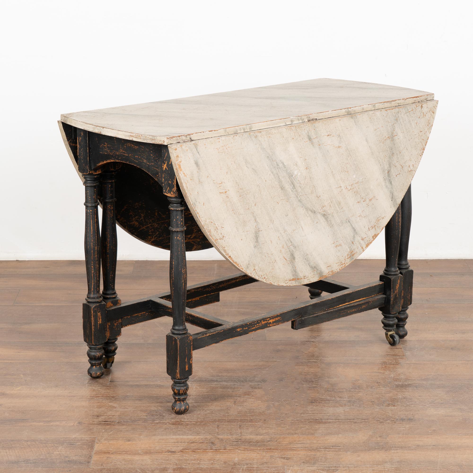 There is wonderful charisma to this drop leaf gate leg table due to the varied colors of the faux marble painted top, which was a favorite style element in the 1800's.
This type of drop leaf was common in Sweden, as they were experts in utilizing
