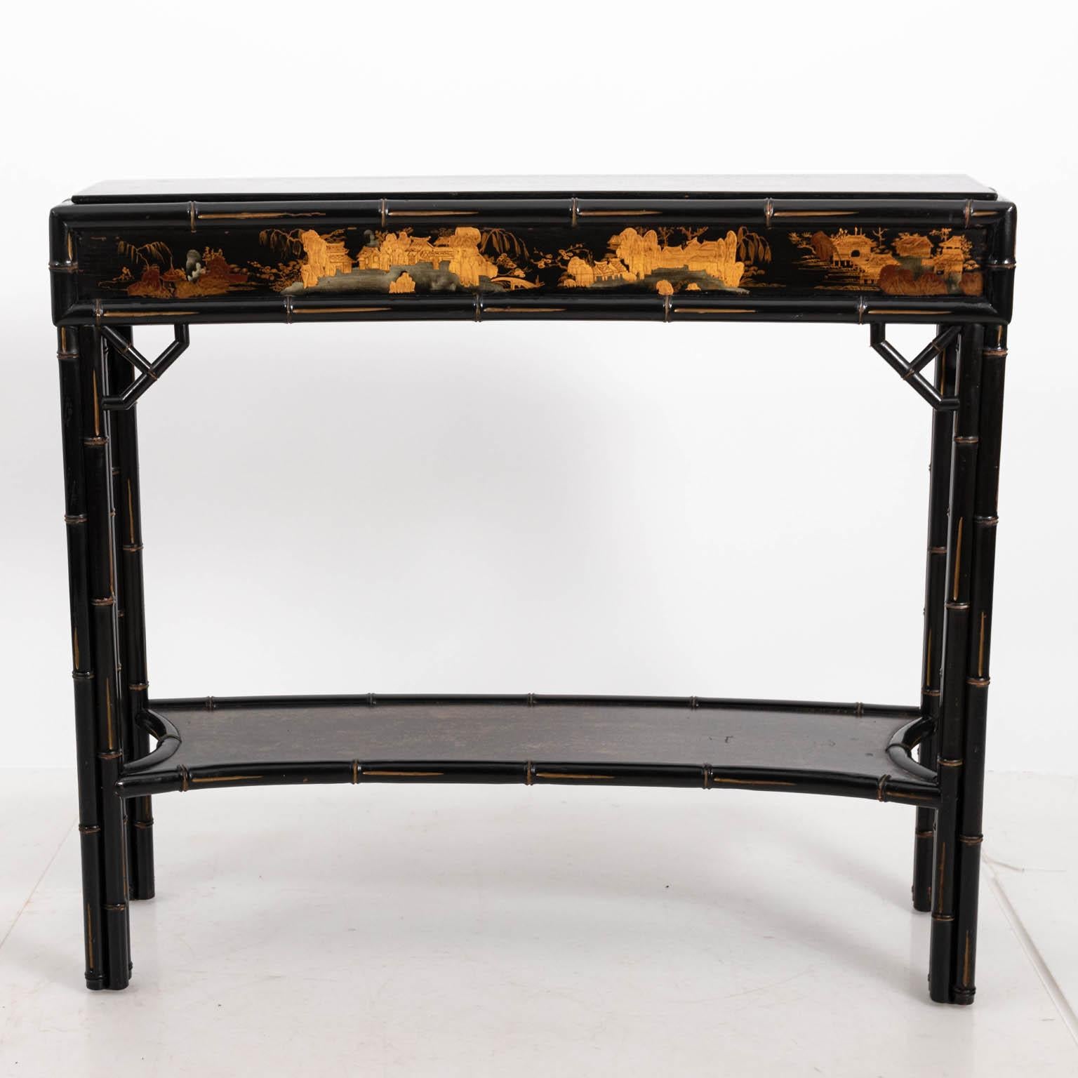 Black painted Hollywood Regency style two-tier console table with chinoiserie style faux bamboo detail and concave front, circa 1970-1980s. Please note of wear consistent with age.