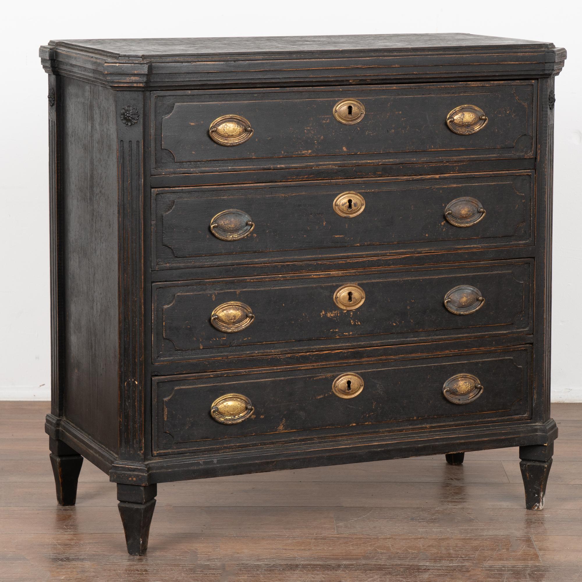 Swedish pine chest of drawers with professional custom black painted finish.
Top with profiled edge, canted carved sides and raised on tapered feet.
Four drawers with raised panels and two brass pulls each.
Restored, later professional painted and